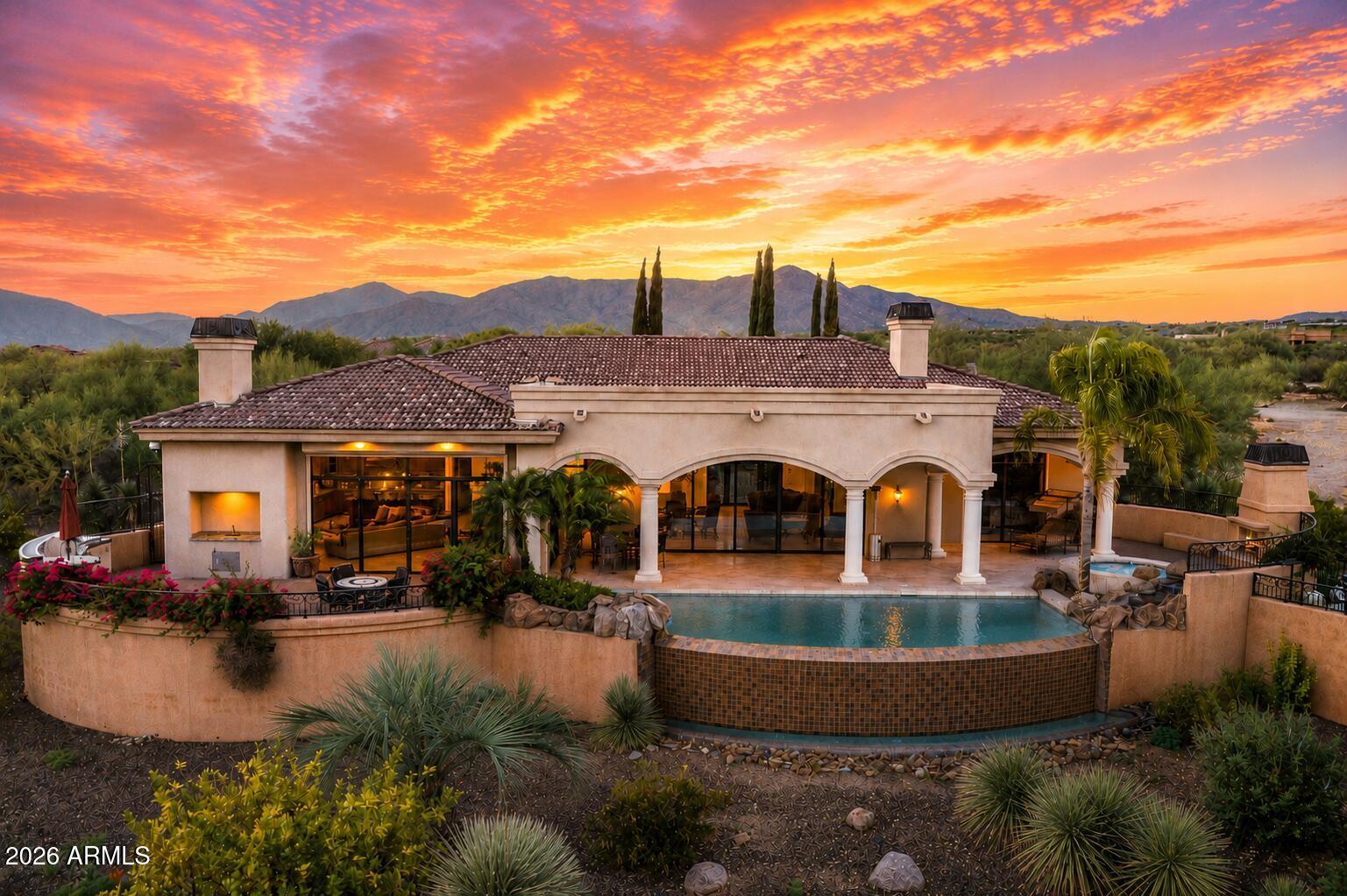 PRIME LOCATION I PRIVATE GATED ENCLAVE | GUEST HOUSE & THEATRE |
Tucked inside an exclusive gated community of only four homes, this custom Tuscan
estate was originally built as the developer's personal residence, offering a level of
privacy and craftsmanship that is rarely available in North Scottsdale. A grand
Mediterranean courtyard welcomes you into a stunning grand living room followed by five ensuite
bedrooms, a split floor plan, and separate formal and casual entertaining spaces
designed for everyday living and large gatherings alike. The chef's kitchen features
granite countertops, a large center island, a private wine cellar, and flows seamlessly to
multiple outdoor living areas. The primary suite is a private retreat with a double-sided
gas fireplace, coffee and wine bar, dual walk-in closets, a soaking whirlpool tub, and an oversized walk-in shower. A detached guest house, dedicated theatre, private office with custom built-in bookcases, and three-car garage provide flexibility for guests, work,
and recreation. Outdoors, the resort-style negative edge pool and spa with boulder waterfall, outdoor kitchen, multiple gas fireplaces, and sweeping mountain, desert, and city light views create an exceptional setting for entertaining year-round. The home is
fully automated with HVAC controls, lighting, interior and exterior sunscreens, central vacuum, Control 4 wiring, security system, on-demand hot water, water softener, and premium theatre surround sound. Located minutes from Bartlett Lake, some of the most renowned golf courses, plus, El Encanto, Mastro's Steakhouse, The Italian Daughter for fine dining. This is a RARE opportunity to own one of the area's most distinctive private estates.