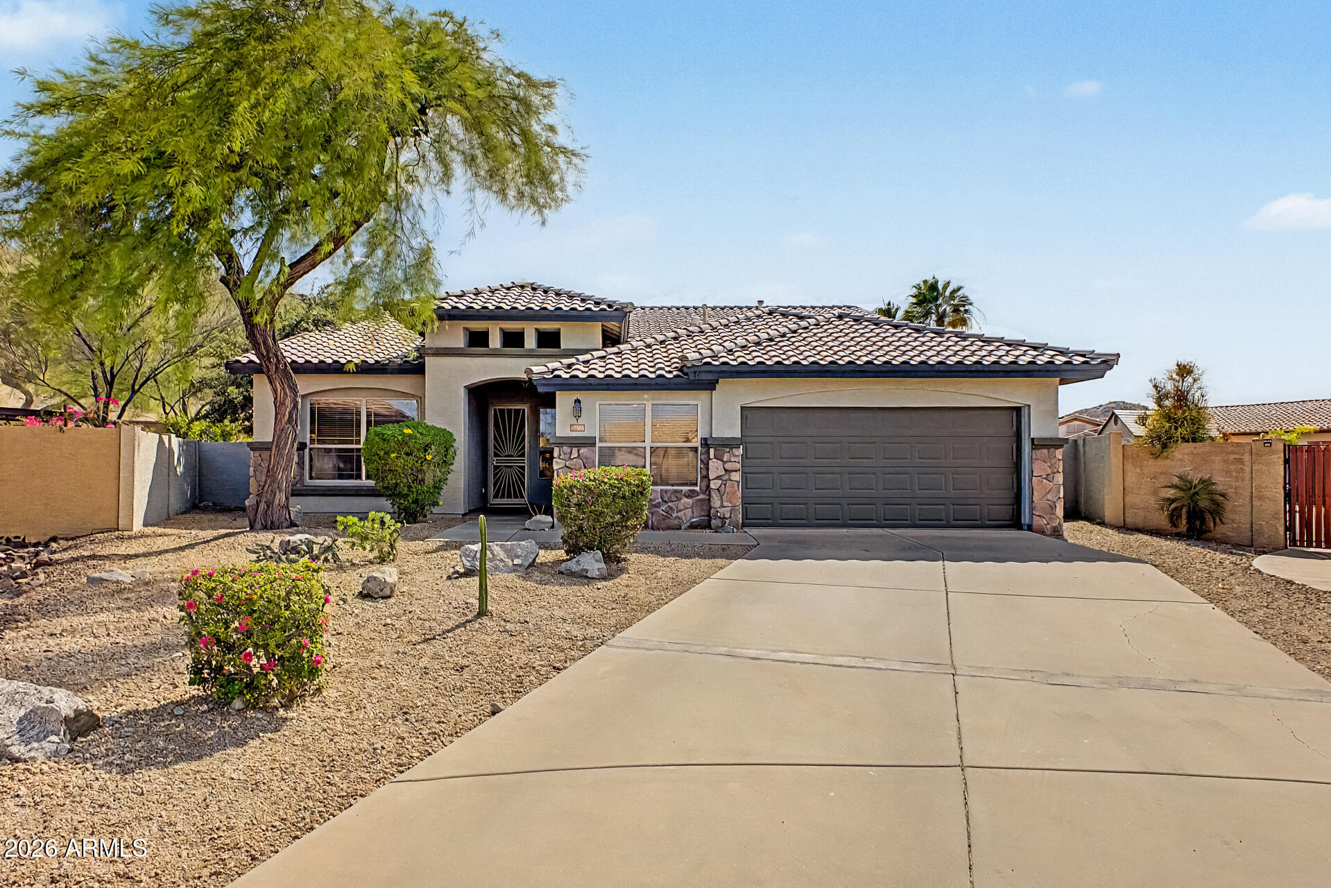 Fantastic opportunity to own this stunning home on a peaceful cul-de-sac! You're welcomed by a 2-car garage, eye-catching stone accents, and a charming desert landscape. Fall in love with the inviting living room featuring high ceilings, blinds, and a harmonious blend of soft carpeting and tile flooring. Gather loved ones in the great room, complete with direct backyard access for seamless indoor-outdoor living. The gourmet kitchen comes with ample wood cabinetry, recessed lighting, sleek stainless steel appliances, a handy pantry, and an island with a breakfast bar. Double doors lead to the cozy primary bedroom, showcasing an ensuite with double sinks and a convenient walk-in closet. One of the bedrooms includes a versatile sitting room ideal for an office or lounge. Imagine enchanting evenings in the sizeable backyard, boasting breathtaking mountain views for a picturesque backdrop, a covered patio, stylish pavers, and a sparkling pool for cooling down on hot summer days. Make this incredible gem yours! Come enjoy everything Estrella has to offer!