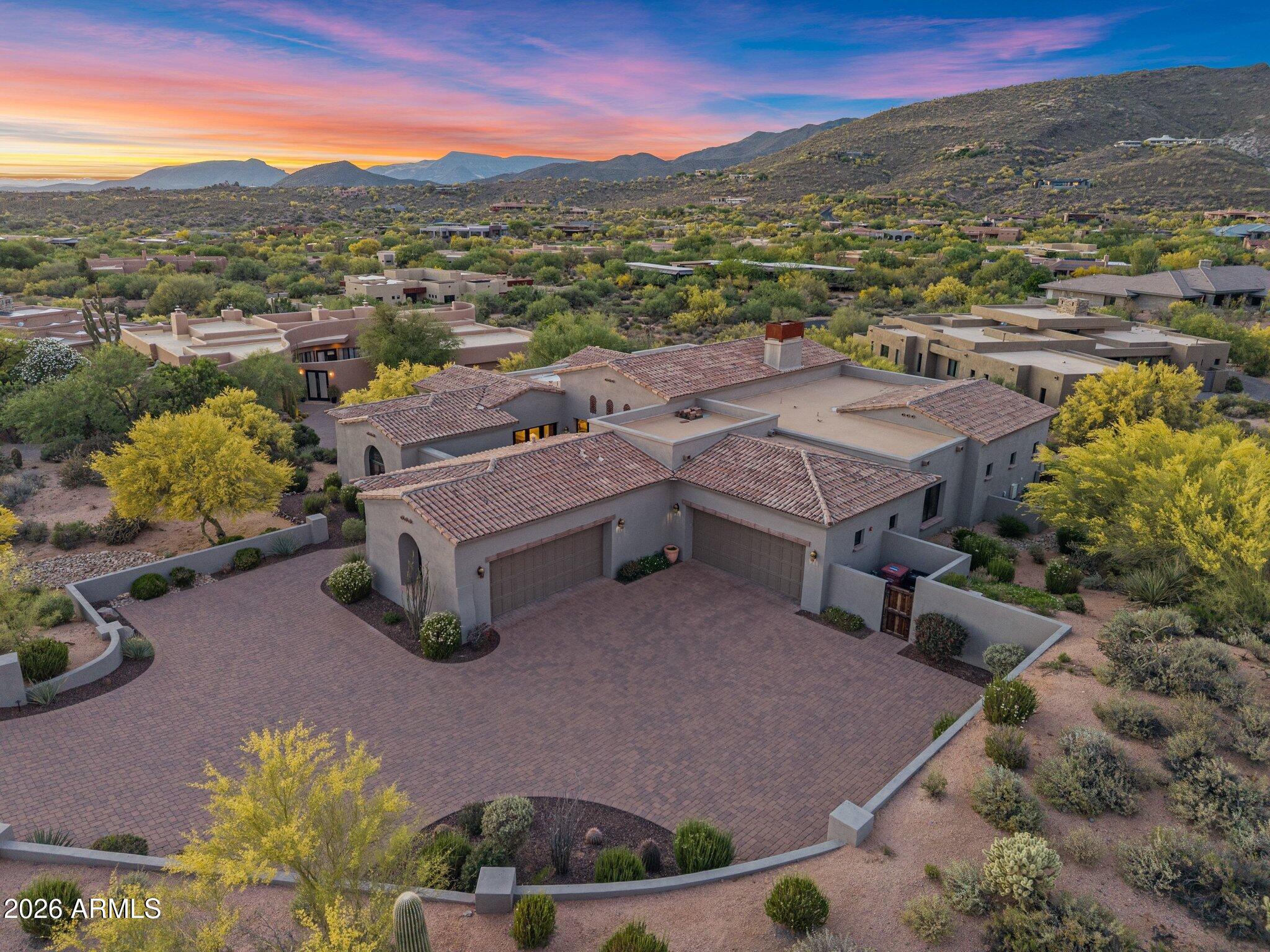NO Steps within this single story Modern Santa Barbara home.Designed for both comfort  and sophistication. Located within the prestigious Desert Mountain community of Scottsdale.  The home captures the essence of elevated desert living with sweeping mountain and sunset views that bring the beauty of the Sonoran Desert indoors.
Thoughtfully designed, the residence features four private suites, a welcoming sitting room, and an expansive open floor plan ideal for both everyday living and refined entertaining. Soaring ceilings, expansive glass, and curated high-quality finishes blend clean modern lines with warmth and timeless elegance. 
The chef's kitchen anchors the home, seamlessly connecting to generous living and dining spaces that flow effortlessly to the outdoors. The primary suite serves as a tranquil retreat with spa-like amenities and direct access to the outdoor living areas.
Outdoor spaces are designed to embrace Arizona's year-round lifestyle, offering serene settings for relaxation or hosting under the desert sky. A spacious four-car garage provides ample room for vehicles, storage, or a collector's needs.
Set within one of North Scottsdale's most sought-after communities, this exceptional property delivers privacy, refined design, and a premier Desert Mountain lifestyle.
Desert Mountain Membership is not available with this property. Buyers may join the waitlist for membership.