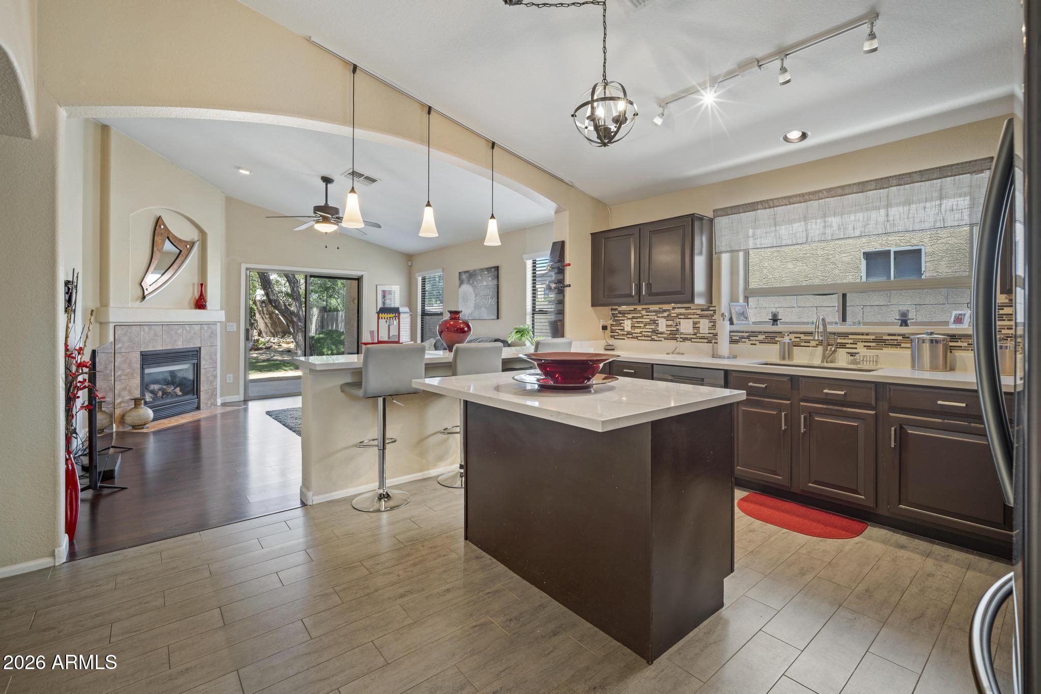 Beautifully updated North Phoenix home with soaring vaulted ceilings and a functional floor plan designed for everyday living and entertaining. The formal living and dining spaces create a welcoming first impression, while the kitchen and family room flow seamlessly together around a cozy gas fireplace. The remodeled kitchen features new quartz countertops, painted cabinetry with updated hardware, under cabinet lighting, new appliances, a spacious island, breakfast bar, and a walk-in pantry. Thoughtful upgrades continue throughout the home including new quartz bathroom countertops, a beautifully tiled primary shower, all new door hardware, ceiling fans, and blinds. The spacious primary suite offers a large walk-in closet and an updated bathroom retreat. Step outside to enjoy a low maintenance backyard complete with a covered gazebo, hot tub hookup, and mature fruit trees including pomegranate, lime, and lemon. Additional highlights include a 2 car garage and numerous updates that make this home truly move in ready. Conveniently located near all that the Shops at Norterra have to offer with easy access to dining, shopping, entertainment, and major employment corridors including the nearby TSMC campus. This one checks all the boxes!