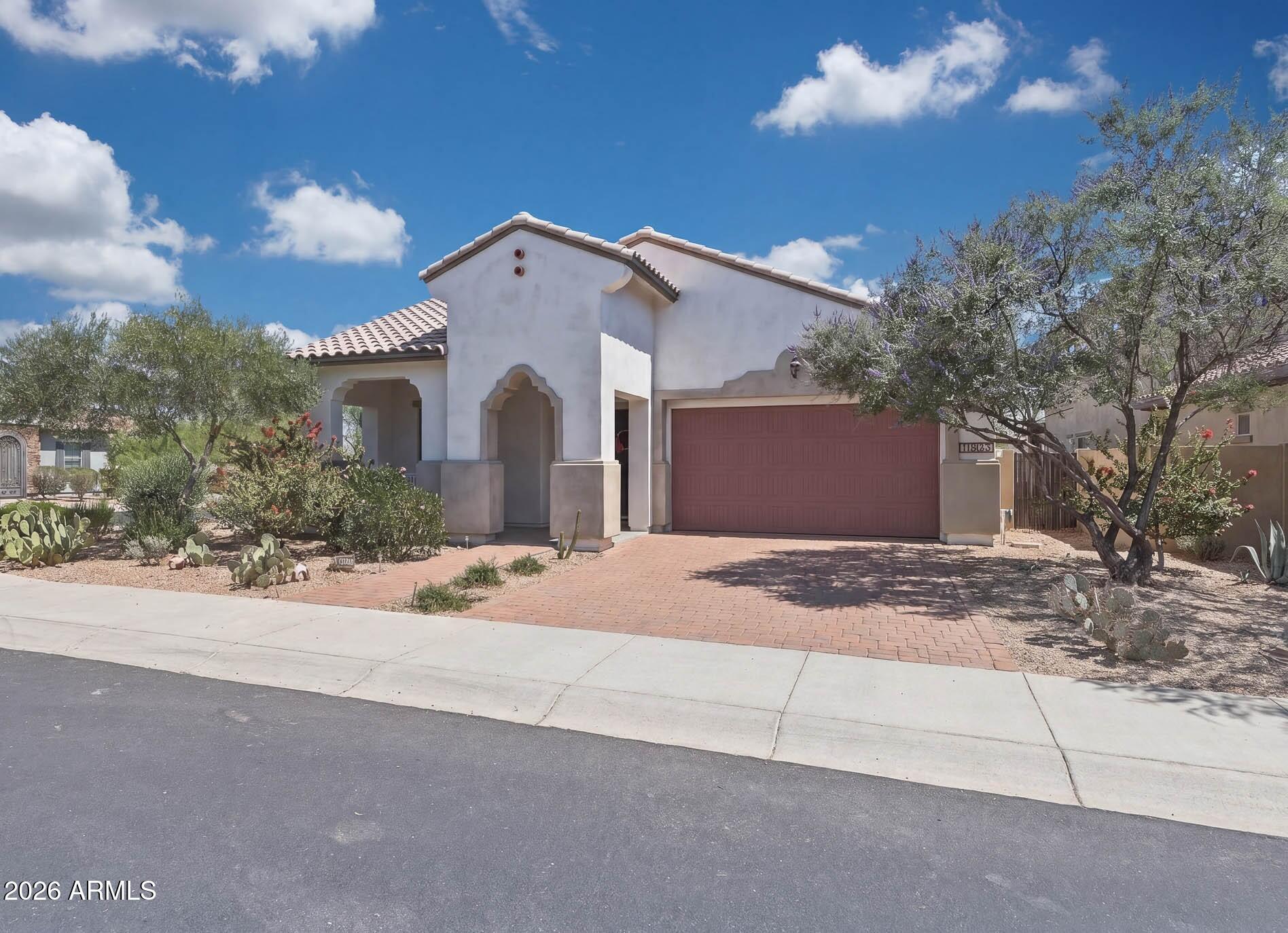 Tucked inside the gated Golf Ridge community of Estrella, this Move in Ready home blends thoughtful design with everyday comfort. Offering 3 bedrooms, 2.5 baths, and a versatile flex space ideal for a home office or den. The layout is both functional and refined. From the moment you step inside, soaring ceilings and a tray-detailed foyer create an inviting first impression. The heart of the home is a beautifully appointed kitchen featuring rich maple cabinetry, quartz countertops, a large island with breakfast bar, walk-in pantry, and S/S appliances including gas cooking. The open great room design makes it ideal for both entertaining and relaxed living. The primary suite offers a unique and convenient connection to the laundry room (washer & dryer included), while the secondary bedroom share a Jack-and-Jill bath, each with its own private vanity and spacious walk-in closet. Additional highlights include plantation shutters, surround sound, updated interior paint (2023), and a 2-car garage with extensive cabinetry. Energy efficiency is a bonus with a prepaid solar system helping keep utility costs down. Situated on a desirable corner lot with no direct rear neighbor just a peaceful common area behind the backyard offers an extended covered patio and low-maintenance landscaping, perfect for enjoying Arizona evenings. Out front, a paver driveway, mature landscaping, and a charming porch with mountain views create standout curb appeal. Life in Estrella means access to resort-style amenities including golf, lakes, pools, fitness centers, scenic parks, and miles of hiking trails all surrounded by stunning mountain views.
