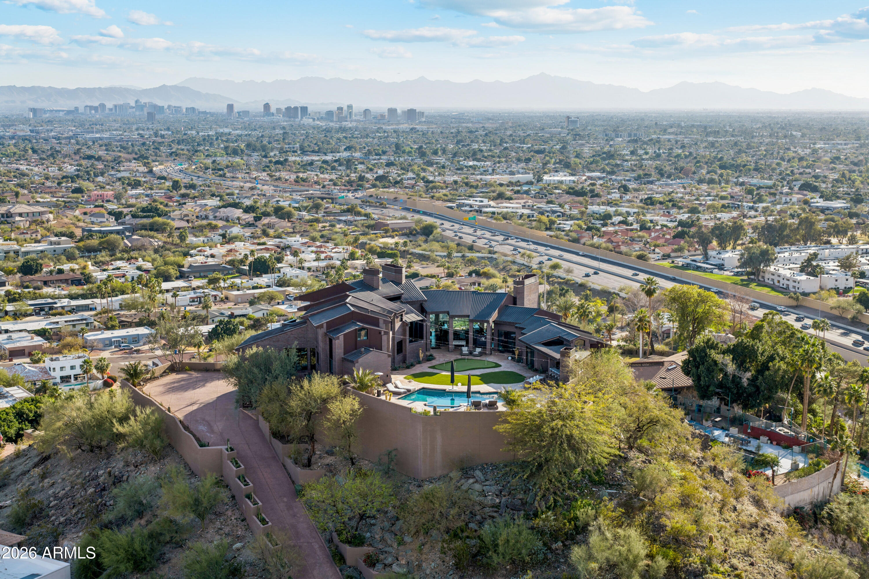In all of Phoenix, there's only one like this. With world-renowned architecture, unparalleled views, and a ''wow'' factor that surpasses even Paradise Valley and Scottsdale, this home is truly once-in-a-lifetime. This masterpiece was designed by the well-known architecture group, Swaback Partners. This home dazzles and delights; the pictures truly don't even do justice to the jaw-dropping 360* views. Luxurious, bright golden light enriches each room through floor-to-ceiling glass windows. All 5 bedrooms boast an en-suite bathroom. The great room stuns with a huge wraparound bar built for entertaining. Soak in the unbelievable desert vistas and natural light beneath the soaring ceilings, expansive layout, and intriguing design in one of the highest perched homes in all of Phoenix.