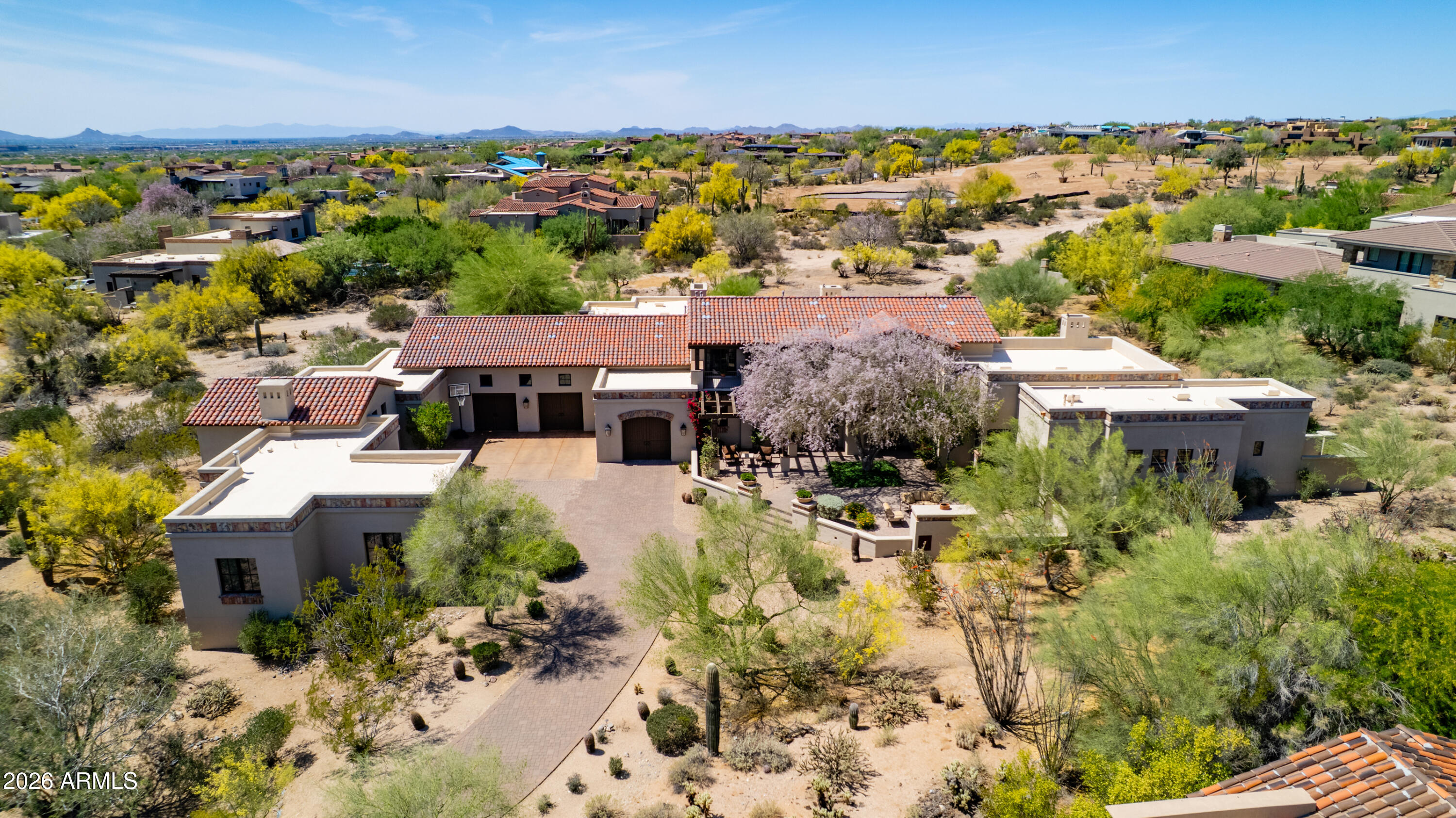 Thoughtfully designed for refined living, this exceptional residence in the prestigious guard-gated community of the Country Club at DC Ranch is perfectly positioned on a private cul-de-sac, elevated by a scenic drive-up approach and framed by serene Sonoran Desert surroundings. Backing to an expansive desert landscape with the golf course beyond, the setting captures beautiful mountain views, glowing sunsets, and an exceptional sense of privacy--complemented by a rare, expansive backyard offering seldom found within the community.

A charming entry courtyard welcomes with a fireplace and multiple seating areas--an inviting introduction to the home's seamless indoor-outdoor lifestyle. Beyond, expansive glass doors and walls of windows flood the interiors with natural light, creating a bright, airy ambiance throughout.

Designed for both everyday living and elevated entertaining, the home centers around a spacious great room with beamed ceilings, a striking cantera stone fireplace, and seamless access to the backyard. A well-appointed wet bar connects the living spaces, enhancing flow between the great room and the chef's kitchen.

The kitchen is a true showpiece--thoughtfully remodeled in 2024--featuring granite countertops, a generous eat-in island, full-height backsplash, and a suite of premium appliances including Wolf (six-burner gas cooktop, double ovens, vent hood, built-in microwave), Sub-Zero refrigeration, and dual Cove dishwashers. Just off the kitchen, a versatile den or flex space offers endless possibilities--from a media room to a playroom or executive office.

The thoughtfully designed split floor plan provides both comfort and privacy. The primary suite is a true retreat, opening directly to the backyard and showcasing a cozy cantera fireplace, crown molding, and a spa-inspired bath with dual vanities, dual water closets, dual wardrobes, and a soaking tub. A secondary bedroom and bath are positioned on the same wing, while two additional en-suite bedrooms with walk-in closets occupy the opposite side of the home.

Upstairs, a loft-style bonus room with a full bath offers an ideal flex space for a game room, office, or guest retreat. The space is further enhanced by a private balcony showcasing beautiful McDowell Mountain views.

The outdoor living experience is nothing short of extraordinary. Set against a backdrop of natural desert landscape with the golf course beyond, the expansive backyard--enhanced in 2024--features a **sprawling grassy lawn--an uncommon luxury in DC Ranch--**alongside a pool and spa, built-in barbecue, and a wraparound covered patio with pavered surfaces designed for year-round enjoyment. The setting is remarkably private, with unobstructed desert views and minimal visibility from neighboring homes.

Additional highlights include an attached private-entry casita with living area, bedroom, full bath, and breakfast bar; a separate private gym with full bath; a fully renovated utility room with dual stacked washer/dryer sets, built-in desk, and abundant storage; and an oversized six-car garage complete with storage cabinetry, EV charging, and lift-ready capacity.

With refined finishes throughout--including travertine and wood flooring, alder wood doors, and thoughtful 2024 updates to the kitchen, fixtures, paint, landscaping, backyard, pool, spa, and pavers--this residence presents a rare opportunity to enjoy luxurious living in one of North Scottsdale's most sought-after golf communities.