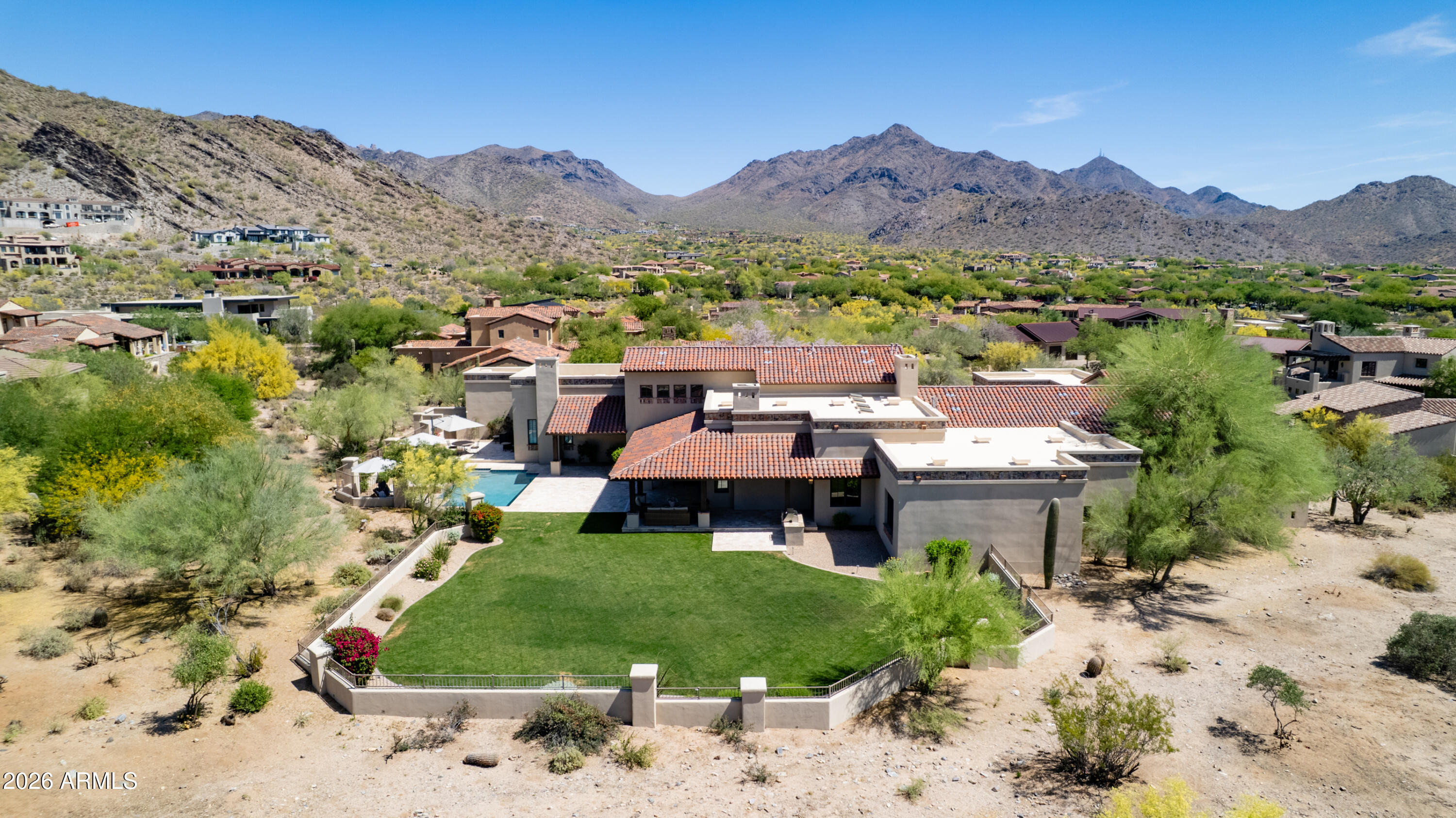 Thoughtfully designed for refined living, this exceptional residence in the prestigious guard-gated community of the Country Club at DC Ranch is perfectly positioned on a private cul-de-sac, elevated by a scenic drive-up approach and framed by serene Sonoran Desert surroundings. Backing to an expansive desert landscape with the golf course beyond, the setting captures beautiful mountain views, glowing sunsets, and an exceptional sense of privacy--complemented by a rare, expansive backyard offering seldom found within the community.

A charming entry courtyard welcomes with a fireplace and multiple seating areas--an inviting introduction to the home's seamless indoor-outdoor lifestyle. Beyond, expansive glass doors and walls of windows flood the interiors with natural light, creating a bright, airy ambiance throughout.

Designed for both everyday living and elevated entertaining, the home centers around a spacious great room with beamed ceilings, a striking cantera stone fireplace, and seamless access to the backyard. A well-appointed wet bar connects the living spaces, enhancing flow between the great room and the chef's kitchen.

The kitchen is a true showpiece--thoughtfully remodeled in 2024--featuring granite countertops, a generous eat-in island, full-height backsplash, and a suite of premium appliances including Wolf (six-burner gas cooktop, double ovens, vent hood, built-in microwave), Sub-Zero refrigeration, and dual Cove dishwashers. Just off the kitchen, a versatile den or flex space offers endless possibilities--from a media room to a playroom or executive office.

The thoughtfully designed split floor plan provides both comfort and privacy. The primary suite is a true retreat, opening directly to the backyard and showcasing a cozy cantera fireplace, crown molding, and a spa-inspired bath with dual vanities, dual water closets, dual wardrobes, and a soaking tub. A secondary bedroom and bath are positioned on the same wing, while two additional en-suite bedrooms with walk-in closets occupy the opposite side of the home.

Upstairs, a loft-style bonus room with a full bath offers an ideal flex space for a game room, office, or guest retreat. The space is further enhanced by a private balcony showcasing beautiful McDowell Mountain views.

The outdoor living experience is nothing short of extraordinary. Set against a backdrop of natural desert landscape with the golf course beyond, the expansive backyard--enhanced in 2024--features a **sprawling grassy lawn--an uncommon luxury in DC Ranch--**alongside a pool and spa, built-in barbecue, and a wraparound covered patio with pavered surfaces designed for year-round enjoyment. The setting is remarkably private, with unobstructed desert views and minimal visibility from neighboring homes.

Additional highlights include an attached private-entry casita with living area, bedroom, full bath, and breakfast bar; a separate private gym with full bath; a fully renovated utility room with dual stacked washer/dryer sets, built-in desk, and abundant storage; and an oversized six-car garage complete with storage cabinetry, EV charging, and lift-ready capacity.

With refined finishes throughout--including travertine and wood flooring, alder wood doors, and thoughtful 2024 updates to the kitchen, fixtures, paint, landscaping, backyard, pool, spa, and pavers--this residence presents a rare opportunity to enjoy luxurious living in one of North Scottsdale's most sought-after golf communities.