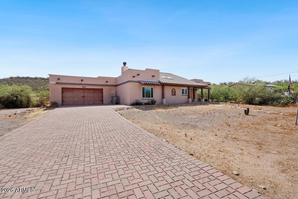 Perfect hobby farm setup on 1.4 acres with mountain views and easy access to I-17 for a convenient commute to the Phoenix metro area. The home features a desirable split-bedroom floor plan, spacious family room and a well-designed kitchen with abundant storage, stainless steel appliances, and an adjoining dining/living area with a cozy wood-burning fireplace. The primary suite offers a cedar-lined walk-in closet, dual sinks, custom tile, and a Jacuzzi tub. Recent upgrades include a new HVAC system (2022), new roof (2024), and new windows (2024). Tile throughout the main living areas, while the bedrooms and finished 24' x 14' basement feature new carpet. Fresh interior paint is underway.  A barn for animals, storage sheds and gazebo for enjoy the private back yard.  Room to ad much more!