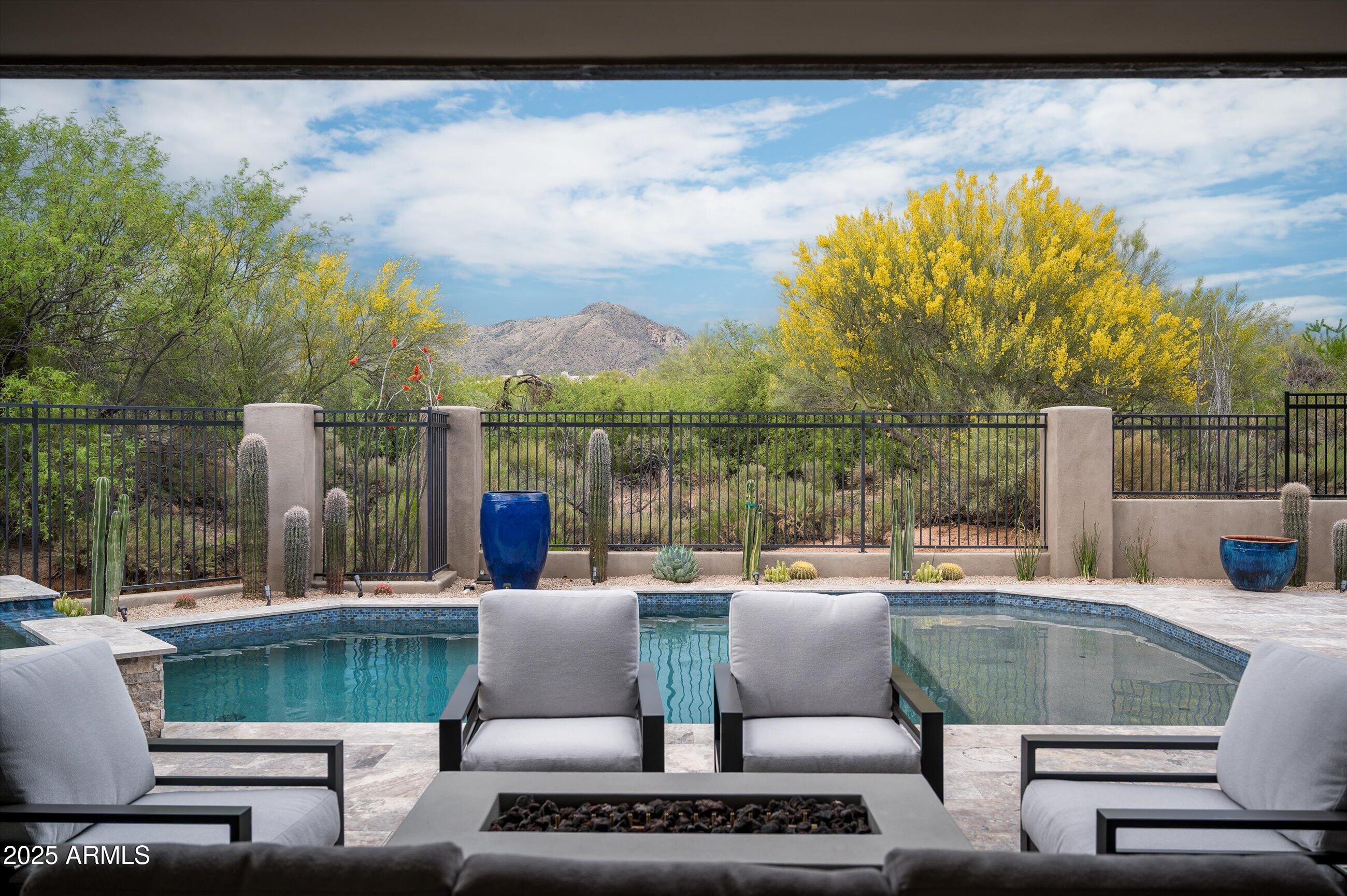 Welcome to your Desert Mountain sanctuary—a custom-built, single-level estate that seamlessly blends elegance with the relaxed charm of Sonoran Desert living. Ideally situated near both gates and the Sonoran Fitness & Spa, this thoughtfully designed home offers resort-style living in one of Arizona's most prestigious communities. Boasting five bedrooms, four of which are en-suite, and two additional bonus rooms, the flexible floor plan is ideal for personalized living—whether you desire a home office, creative studio, den, or music room. Throughout the home, wide plank oak flooring, custom lighting fixtures, and timeless finishes create a warm yet refined ambiance. The heart of the home is the spacious great room, highlighted by a striking granite fireplace surround and flowing seamlessly into the gourmet kitchen. Outfitted with chef's-choice appliances and ample workspace, the kitchen is designed to delight culinary enthusiasts and entertainers alike. Step outside to your own private resortwhere a brand new pool, spa, built-in BBQ station and fire-pit (completed in 2024) invite relaxation and outdoor gatherings. The high-ceiling covered patio offers a peaceful setting to take in panoramic views of Apache Peak, Lone Mountain, and the vibrant Sonoran landscape. Golf membership is available through The Desert Mountain Club; please note a 30-day application process and a waitlist may apply. With its prime location, exceptional craftsmanship, and breathtaking natural surroundings, this home is a rare opportunity to experience the best of Desert Mountain luxury.