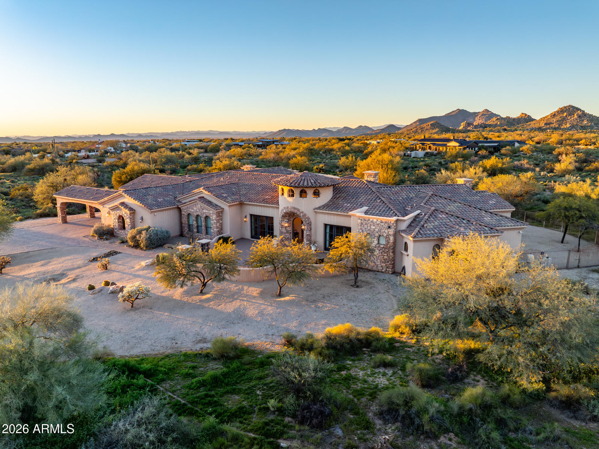 Set on 4.3 private acres in a premier location, this gated estate offers exceptional privacy w/sweeping desert & mountain views. A gated entry and pavered drive lead to a four car garage and fenced courtyard. Inside, soaring 14' ceilings frame a well designed split floor plan with refined architectural details and clear pride of ownership. The home features five bedrooms, five full baths, two half baths, an office, theater room, wet bar, and wine cellar. The kitchen is equipped with high end appliances and an oversized island ideal for entertaining. Expansive glass sliders open to a covered patio with fireplace, pool, and spa. Enjoy Arizona sunrises and sunsets from the rooftop deck. Located in the horse friendly Pinnacle Peak Ranchos community with room to add  equestrian amenities.