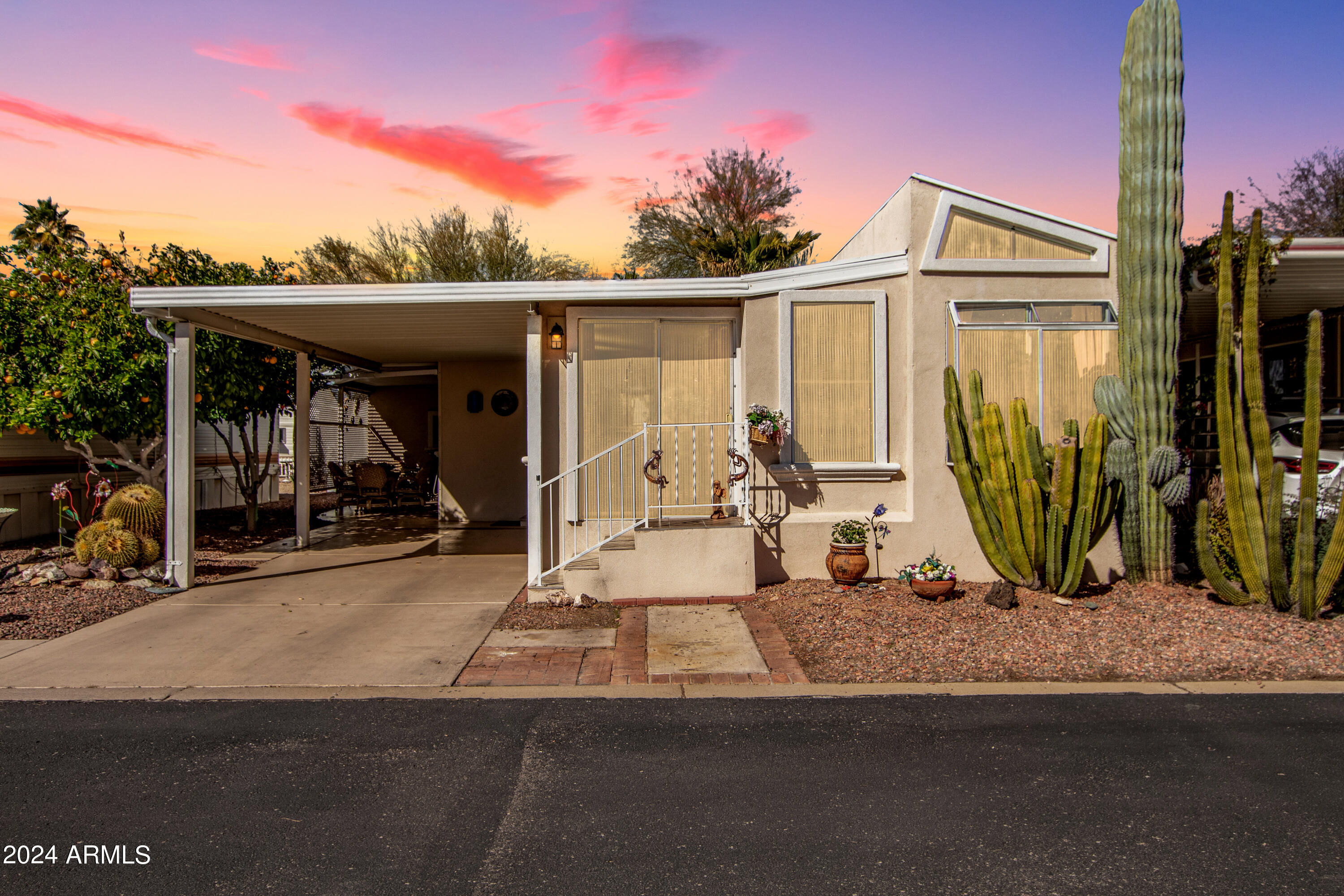 Welcome to Happy Trails Resort, a highly sought-after 55+ guard-gated golf course community, perfect for full-time living or a seasonal snowbird retreat. This well-maintained home offers greenbelt views and a versatile flex room that can be used as an office, guest space, or additional storage. The spacious AZ room overlooks the greenbelt, creating a relaxing setting to enjoy Arizona living. The property features a new irrigation system, mature grapefruit and orange trees, stack washer and dryer, storage shed, and covered parking. Furnishings are available for a turnkey opportunity, making this an ideal lock-and-leave winter home. A golf cart is available on a separate bill of sale. Enjoy resort-style amenities including golf, pools, clubhouse, fitness center year-round social events.