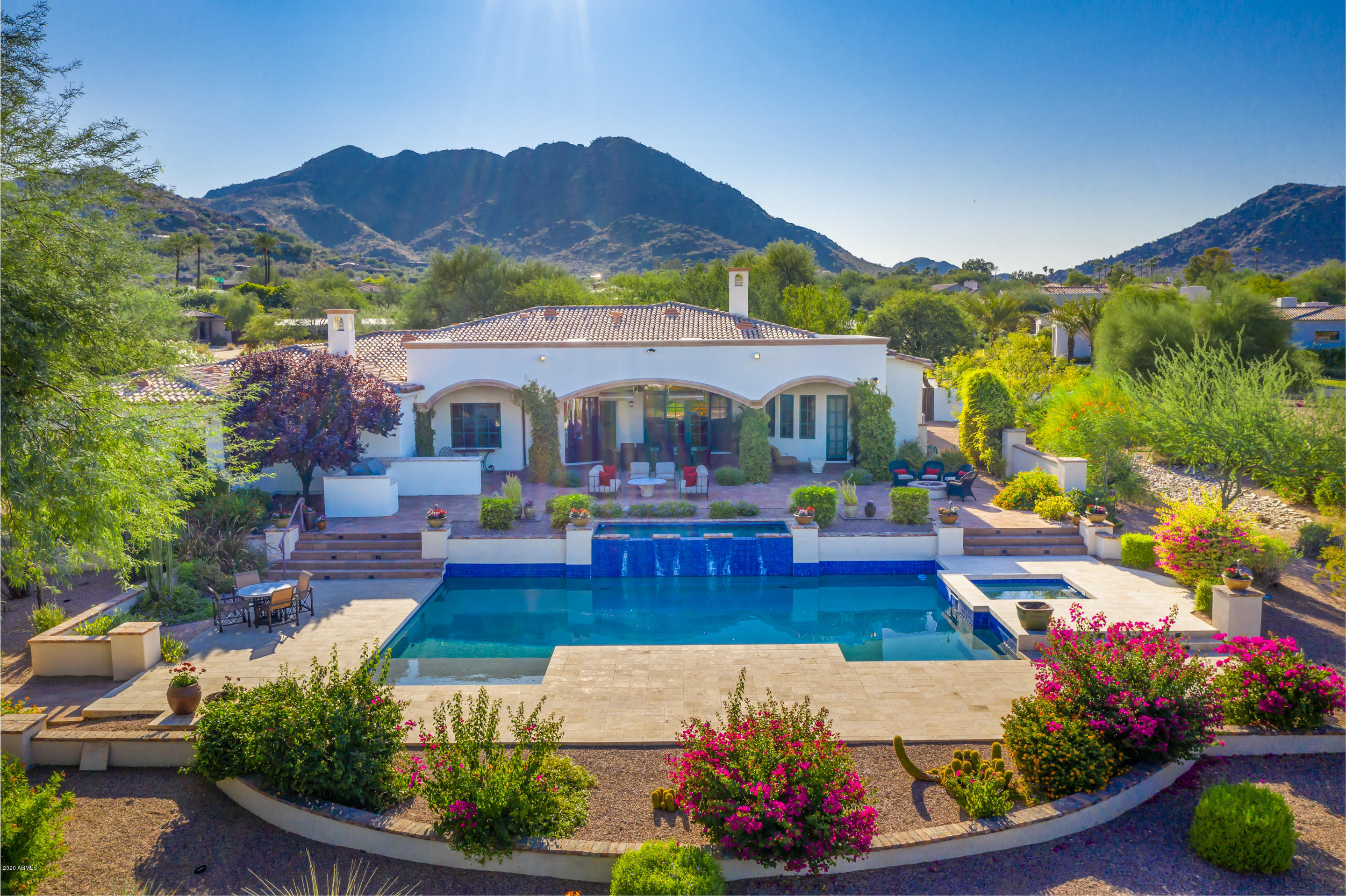 Views of the McDowell Mountains and  Scottsdale city lights greet you as you enter the door of this lovely home on a quiet street in Paradise Valley.  Main home is just over 5000 sq ft with 4 en suite bedrooms, 600 bottle wine cellar, dedicated office and flex room (currently being used as an exercise room). Guest casita is 787 sq feet, 1 bed, 1 bath with kitchen area as well as a covered patio. The backyard is perfect for entertaining with a large covered patio made comfortable year round with a misting system in summer and built in gas heaters for winter. Your friends and family will enjoy sitting by the gas firepit or taking a dip in the lovely pool before gathering around the bbq grill for a delicious meal. The gardener in you will also love the 3 raised ,irrigated beds .
