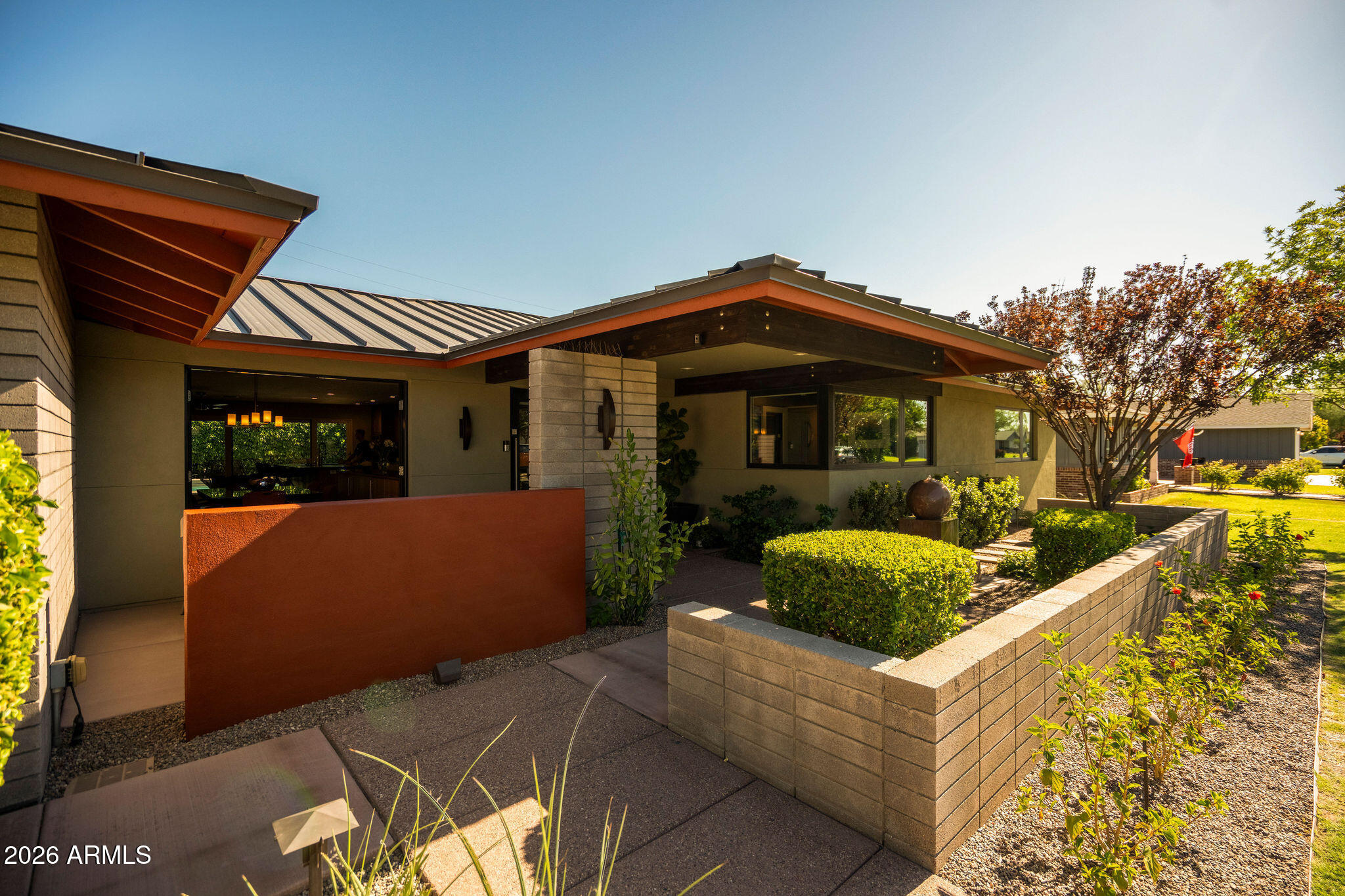 Architect-designed and set on a prime corner lot in the heart of Arcadia, this one-of-a-kind Mid-Century Modern masterpiece blends timeless design with exceptional craftsmanship. Walls of Andersen glass, soaring vaulted ceilings, and warm walnut finishes create a light-filled, seamless indoor-outdoor living experience. The home features 3 ensuite bedrooms, a dedicated office with Camelback Mountain views, media room, chef's kitchen with GE Monogram appliances, and two steam showers. Outside, enjoy a resort-style backyard with a geometric pool, spa, Wolf outdoor kitchen, fire pit and covered entertaining pavilion. Complete with a standing seam metal roof, smart-home technology, air-conditioned 3 car garage, detached flex studio, and countless premium upgrades. Don't miss out!