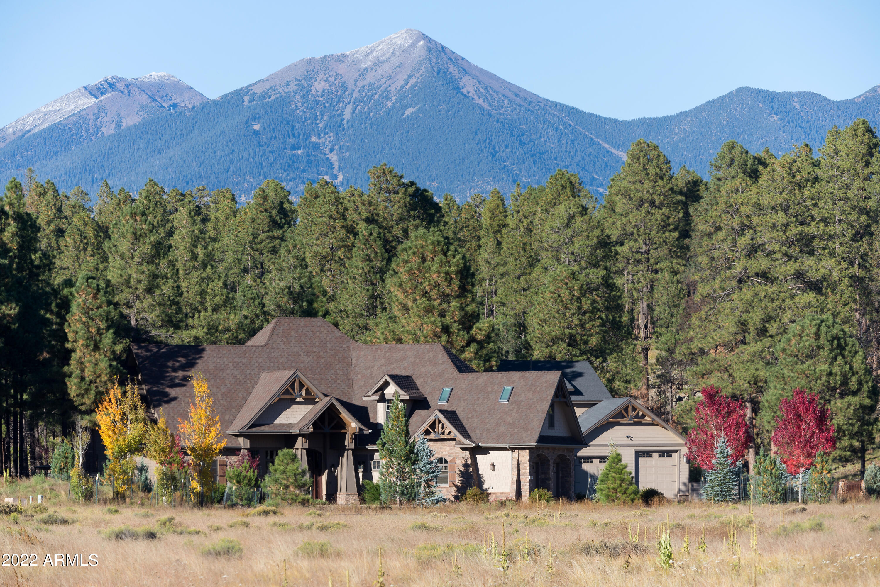 A One-of-a-Kind Custom-Crafted Mountain Luxury Home backing the National Forest in a quiet Gated Community just 7 miles from Down Town Flagstaff. The main home is a 4 Bedroom, 4 Bathroom, with a 3 Car Oversized Garage. The Guest house with separate entry has a 1 Bedroom, 1 Bathroom with an open Kitchen/Dining Great Room above an amazing 2 Bay RV Garage, both on 2 Treed Acres. You will be amazed with the easy flow floor plan in the main home. You are welcomed into a large open central living area, boosting an eat-in Cooks Kitchen with high end appliances, granite counters, prep sink, pantry, bar, and breakfast seating, all set up for entertaining and yet from all directions you have complete privacy. The comfortable great room has art niches, built in cabinets, recessed TV, and the comfort of a highly efficient Ravelli Classic RV 100 Pellet Stove. A formal dining area is also conveniently located near the kitchen area along with a private office space and or library. There are 2 private bedrooms that share a full bathroom. The amazing Arizona Room is seen off the great room area with a wood stove within a custom stone surround, flagstone flooring, Jenn-Air grill and walls of windows bringing the outside in. Through the double glass doors, you will see the covered Aluminum Cupola over the BBQ Station that has a sink and a propane warming plate. The utility room will hold an oversized washer and dryer with a sink and wall mounted ironing board next to a custom powder room and access to a side yard. The spacious Primary Bedroom has a Vaulted Ceiling, oversized closets, access to the outside patio and hot tub. The Primary bathroom with custom cabinets, granite counters, a separate 3 head shower, a must-see Champagne Bubbler Tub, and a makeup counter. The stairway at the front door entry leads to a flex room, with two sitting areas, bathroom and a must-see Home Theater and dry bar. The guest quarters with separate entrance are over the RV Garage that will hold a 32 Foot Class C RV, with attached heated workshop. This Smart Home is wired for music, security cameras, TV's, and Roku in both the main and guest house. Fire suppression sprinkler systems in both homes and a 100 AMP propane powered backup generator is also another feature of this amazing home. The combined square footage is both the main house and quest house. The list of amenities are too long to list. Please print the attached home amenities list in documents, you will be amazed.