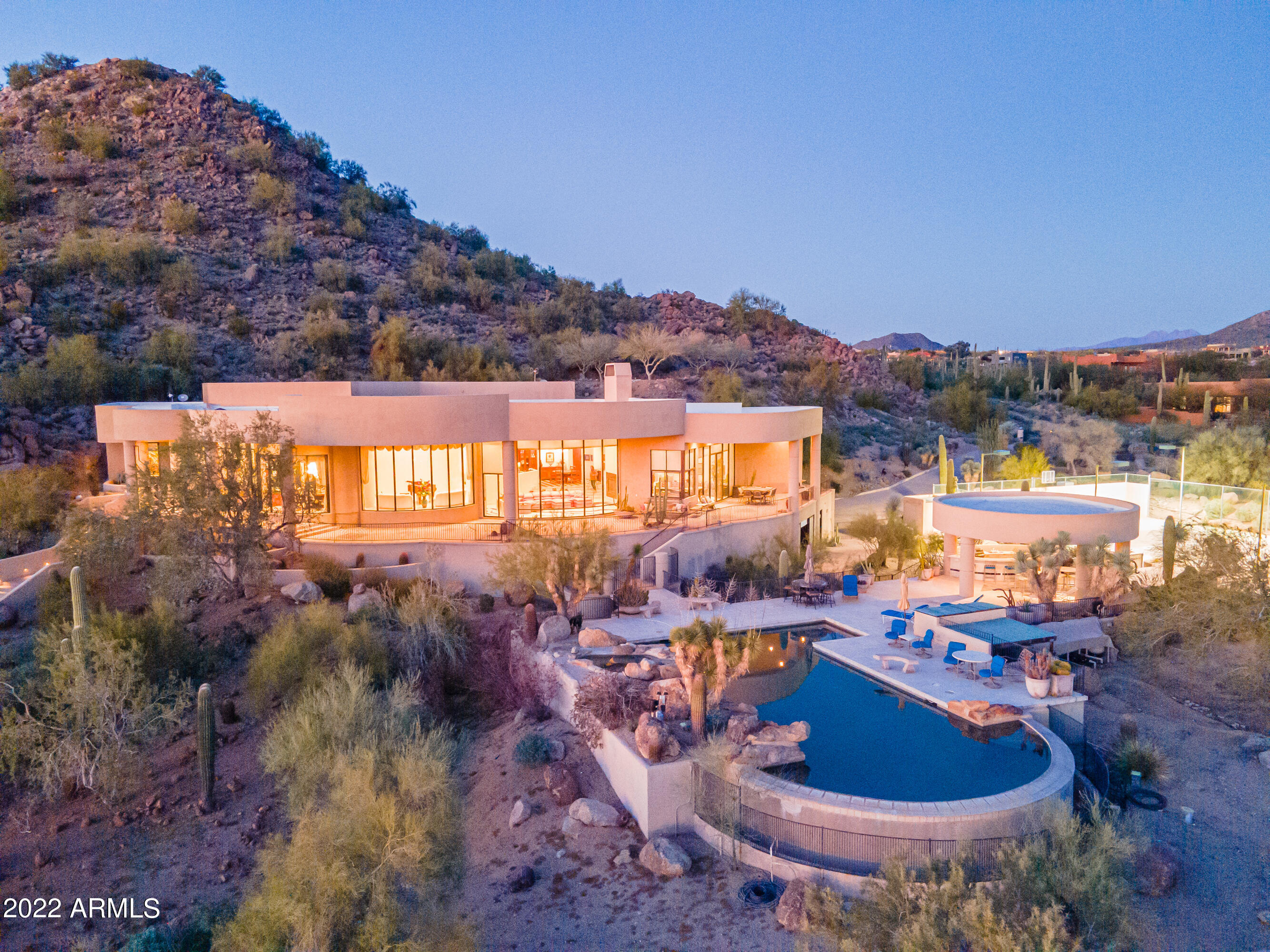 King of the hill 6-acre 8.000 sq/ft estate with unprecedented city and mountain views!!  This expansive property offers benefits like no other hilltop property in the valley.  A substantial detached and extended RV garage plus room for 3 more vehicles, a workshop and huge storage area with loft.  The window package and floor plan design mean views from almost every angle.  This includes the expanded full-size tennis/sport court with custom commercial lighting.  The pool area and commercially built pergola are an entertainer's paradise.  Stairs built to a viewing pad for complete isolation and access to a private hiking trail.  Also included are 3 car garage main house, movie room w/ensuite, workout room w/ensuite, elevator, dumbwaiter. Private well!!  The land value alone is significant.