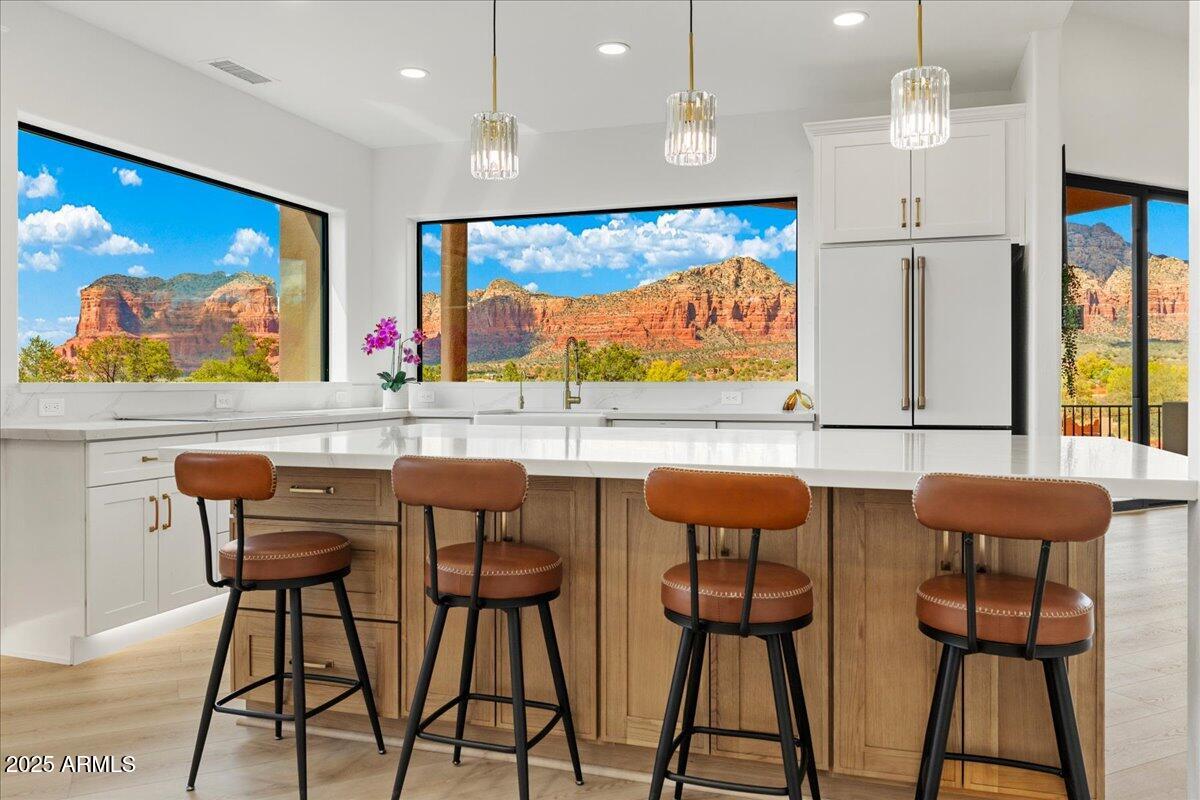Experience a total transformation on this Luxury Sedona estate, set on 2.94 acres with sweeping panoramic Red Rock views and backing to National Forest for complete privacy. Designed to capture Sedona's world-famous red rocks, this modern masterpiece showcases expanded picture windows that bring the outdoors in with unforgettable drama. Step inside to a fresh, refined interior featuring new paint inside and out, luxury vinyl flooring throughout, and designer lighting that casts a warm, elegant glow. At the heart of the home is a gourmet kitchen created for both beauty and function. Picture yourself gathering around the oversized quartz island as the red rocks glow at sunset. Premium Café appliances, quartz countertops, and custom cabinetry with extensive storage create a space that is as stylish as it is practical. Microwave/Oven and induction range make every meal effortless, while three dishwashers ensure entertaining and cleanup are refreshingly simple. The primary suite has been completely modernized with quartz finishes throughout and a spa-like bath featuring a slipper soaking tub, dual-head walk-in shower, bidet, and one of the most impressive walk-in closets you will find. A second primary suite, set on the opposite side of the home, offers equal comfort and privacy for guests.  Step outside to an expanded paver patio with a convenient ramp for easy access, the perfect place to watch Sedona's famous sunsets. Several additional patios invite you to relax, entertain, and experience the beauty of Red Rock country from every angle. This estate combines luxury with rare versatility. Short-term rentals are allowed, horses are welcome - up to six - and the barn provides space for horses, 6+ vehicles, an RV, or a variety of other uses. A three-car attached garage plus an additional one-car detached garage ensures ample parking and storage. Recent upgrades, including two new AC units, two new water heaters, and a whole-house water infiltration system, provide comfort and peace of mind. This Sedona retreat offers an unmatched blend of privacy, elegance, and possibility. Don't miss your chance to own a truly transformed estate where modern luxury meets natural wonder, come and experience it for yourself.