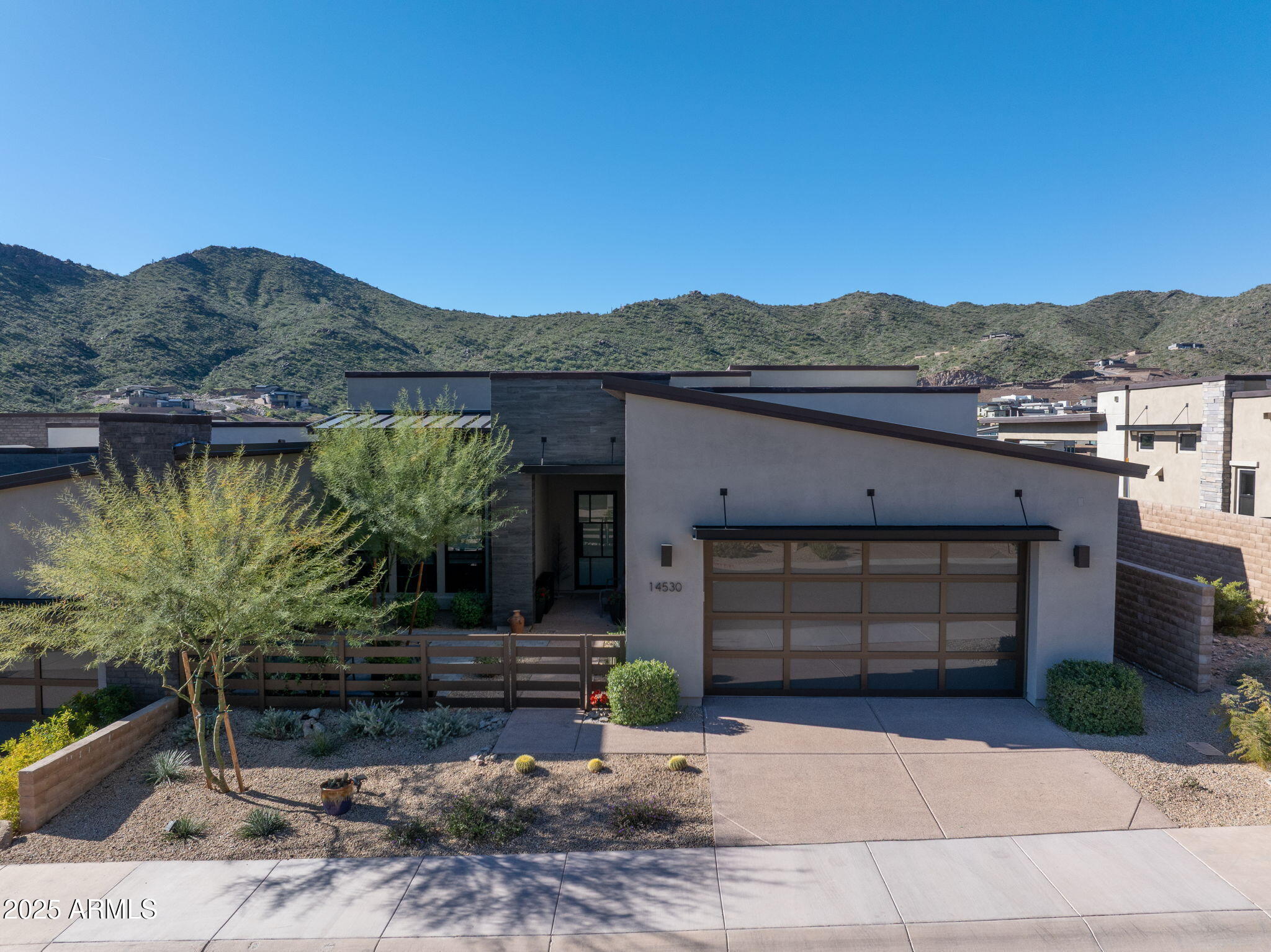 Spectacular elevated modern living at its finest with Views! Light and bright throughout with white cabinets. neutral palette throughout,1 level no steps. Designer finishes, chef's kitchen featuring quartz countertops, huge waterfall island,custom lighting and Wolf and Sub-Zero appliances with double ovens. High ceilings and expansive windows fill the home with natural light, while a 12' multi-slide door opens to seamless indoor-outdoor living with a spacious patio and sweeping views. A 72'' linear fireplace anchors the living area. Dual remote-controlled window treatments offer filtered or blackout light. The primary suite includes a freestanding soaking tub, walk-in shower, oversized closet, and north-side open space for added tranquility. Custom front Courtyard & so much more!