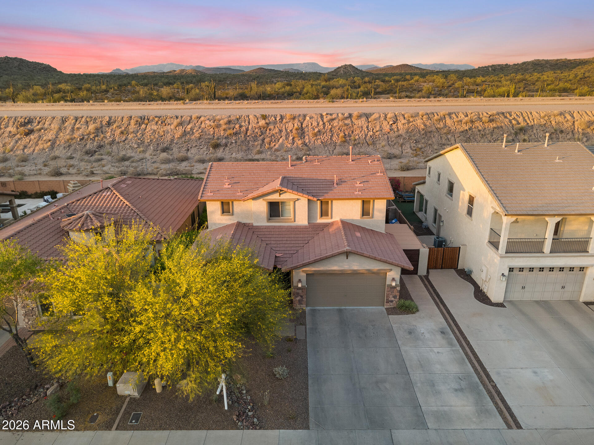 Space, style, and mountain views come together beautifully in this spacious 4 bed / 3 bath two-story home offering 2,409 sq/ft of comfortable living. Designed with flexibility in mind, this home features both a den and loft, providing the perfect setup for a home office, media room, playroom, or additional living space. Elegant 20-inch tile flooring flows throughout the main living areas, while the thoughtfully designed kitchen impresses with granite countertops, a center island, and stunning knotty pine cabinetry complete with under-cabinet lighting and pull-out storage for added convenience. The home's fully remodeled bathrooms add a fresh, modern touch throughout. Upstairs, the primary suite serves as a relaxing retreat with a walk-in closet and full bath, while beautiful mountain views create a scenic backdrop to everyday living. Car enthusiasts, EV owners, and hobbyists will appreciate the epoxy-finished 3-car tandem garage, complete with a Tesla charging station and ample room for storage, projects, or extra parking. Step outside to your entertainer's backyard featuring an outdoor pressurized misting system, built-in BBQ and smoker, and a fire pit, creating the perfect setting for gatherings, relaxing evenings, and enjoying Arizona living year-round.