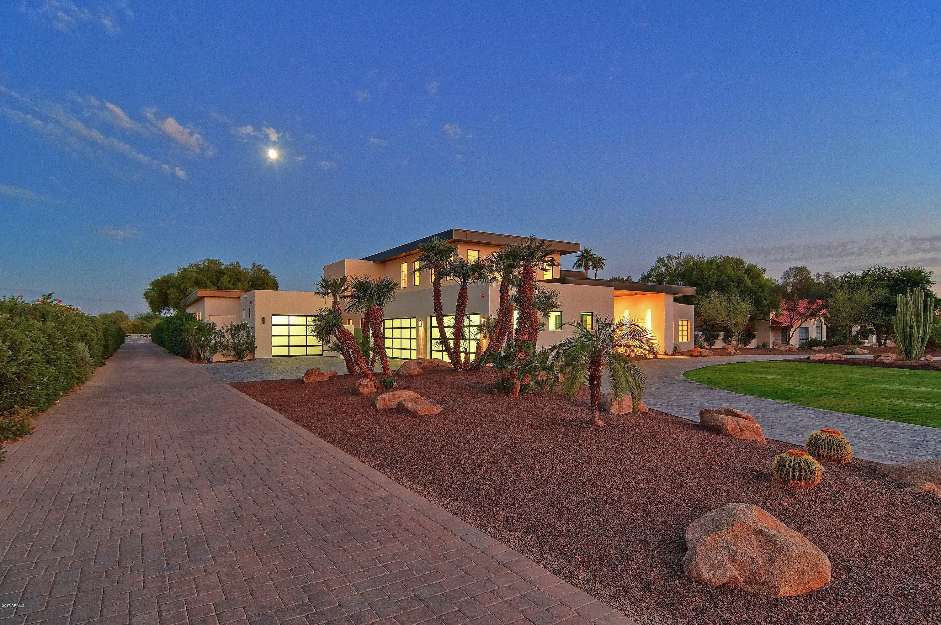 Livable luxury. No expense spared on this brand new stunning contemporary home in beautiful Paradise Valley. Dramatic soaring ceilings & abundant natural light. Amazing design elements & lavish finishes including huge honed Austin limestone columns & DaVinci Safe Touch Glass see through fireplace with split faced Austin limestone finish. Perfect flow for entertaining with a wall of glass that disappears to bring the outdoors in. Wolf,Subzero, Asko appliances, low e insulating argon Pella windows, Bravura hardware, elmwood cabinets. Main house 7120 SF has 5 bedrooms, 7 baths, 2 offices and a game/bonus room. Outdoor kitchen, fantastic pool, 384 SF pool house  with workout room & full bath as well as a n/s fully lit tennis court complete this fabulous backyard. Master bed/bath is a true spa like oasis with walls of glass an office & his and hers closets. The 1018 SF guest house will have your guests wanting to stay with its own 1.5 car garage, kitchen, laundry and glass walls looking onto the lush backyard.
