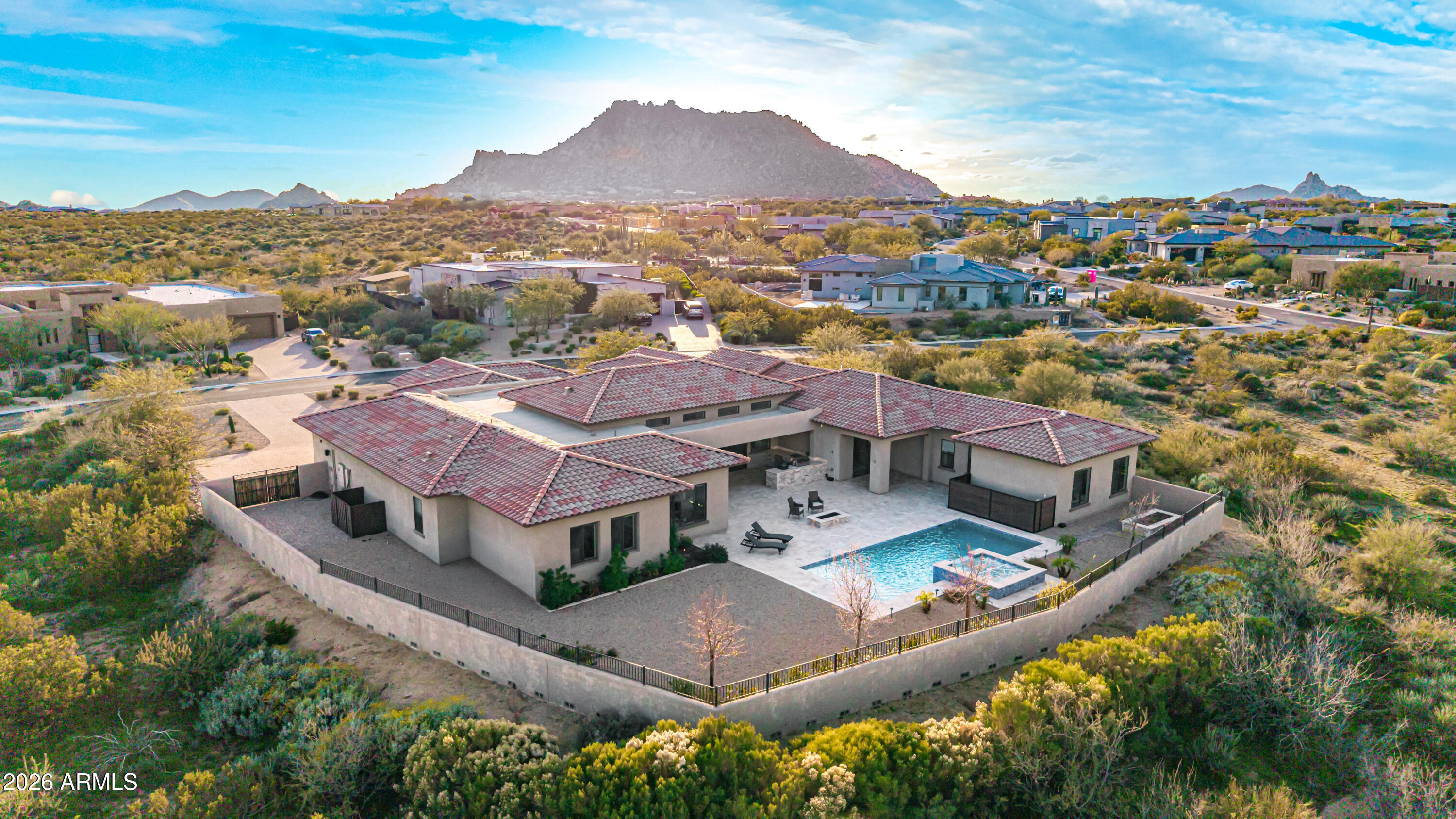 Set on a 1-acre site, this custom estate in the Boulder Ranch gated community, delivers sophistication, scale, and thoughtful design across 5,658 sq ft. The residence includes 3 bedrooms, 4 full baths, and 2 half baths, along with an attached casita—ideal for extended stays or multigenerational living. A rare 5-car garage provides exceptional flexibility for vehicles, storage, or specialty use. Natural Area Open Space behind and between homes enhances visual openness while framing expansive desert views of the McDowell Mountains and Four Peaks. An expansive scullery serves as a functional extension of the chef's kitchen and includes a built-in dog washing station. Pristine and lightly lived in, the home presents with the polish and feel of a near-new custom build. The chef's kitchen is appointed with premium appliances, generous prep space, and designer finishes, connecting seamlessly to multiple indoor and outdoor gathering areas. The backyard was completed in 2023 and showcases a resort-style pool with built-in spa, a substantial built-in BBQ area, and extensive travertine patios surrounding the pool and outdoor living spaces, creating a clean, cohesive, and timeless environment. The gated setting further enhances the overall sense of privacy and quality throughout the property.