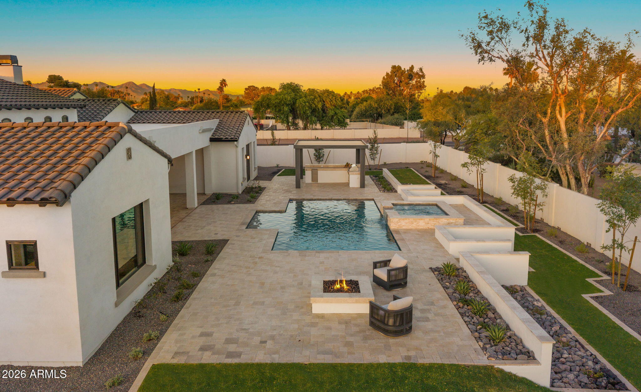 Positioned on more than an acre in the heart of Paradise Valley, this newly constructed estate by Thomas James Homes delivers an exceptional blend of timeless Santa Barbara architecture and modern sophistication. Known for its expansive estates, breathtaking mountain views, and unmatched privacy, Paradise Valley offers one of Arizona's most prestigious lifestyles with world class golf, fine dining, luxury resorts, and premier shopping just moments away. Curated for refined living and effortless entertaining, this single-level residence features 5 bedrooms, 5.5 bathrooms, an attached casita for guests or a dedicated gym or office, and a 5-car garage. The gourmet designer kitchen showcases Wolf and Sub-Zero appliances, a prep kitchen, and double dishwashers. The serene primary retreat offers a spa-inspired bath and expansive walk-in closet. Outdoors, the resort style pool and spa anchored by landscaped grounds including an outdoor kitchen, pergola and firepit, create a private sanctuary where you can unwind under the Arizona sky with Mountain views, host gatherings, and enjoy seamless indoor-outdoor living all year. Exceptional craftsmanship and refined design define this extraordinary Paradise Valley estate.
