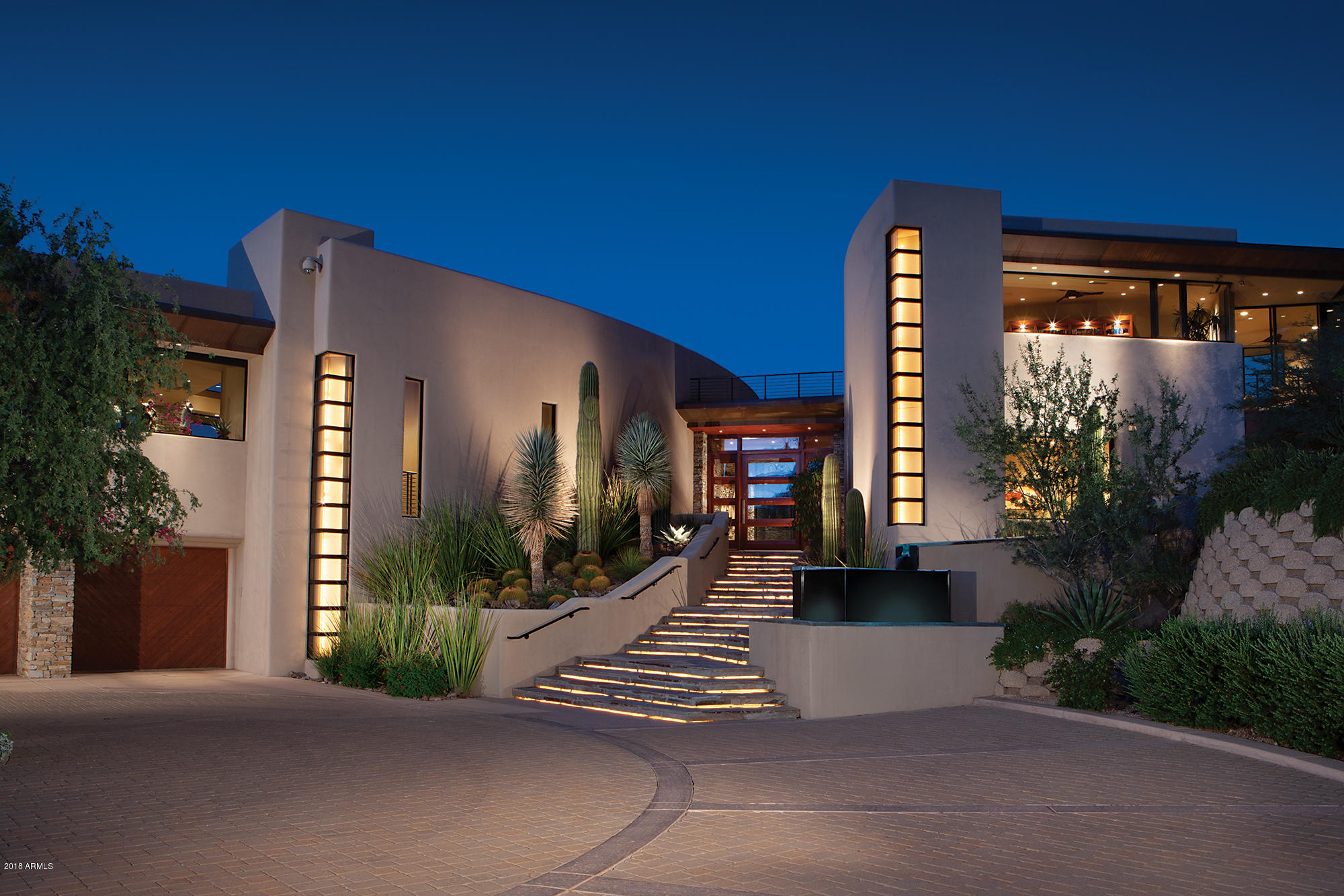 This award winning 6 acre estate was designed by noted architect Bing Hu, this six-acre estate situated on Troon Mountain captures panoramic views of the mountains, the sunset, and the city lights. You enter through a its own private gated entry and romantic driveway leads to this exquisitely designed contemporary home. Every inch of this is filled with drama, high end finishes and attention to details. You will love the chef's kitchen, unique ceiling details, private terraces, fabulous home theater, the breathtaking views and the integrated home automation features that earned the Home of the Year award by Electronic House Magazine. The covered patio, infinity pool, heated spa, 2 fire pits & 2 fountains all embrace the desert and mountain vistas
