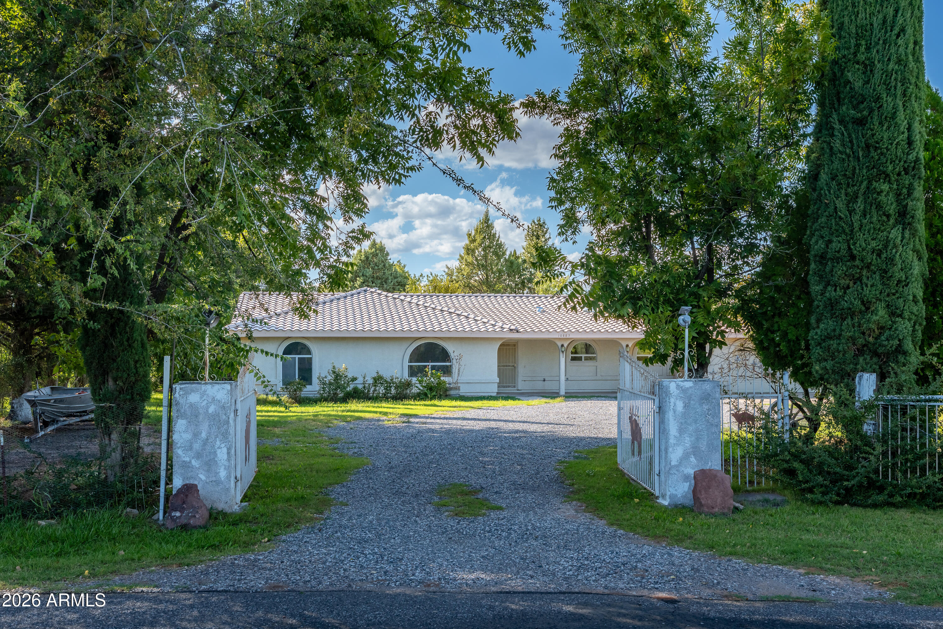 Rare opportunity in Mel Glo Estates! Country living at its finest with the potential for 3.26 irrigated acres and abundant water, including two wells and flood irrigation. This lovingly maintained 3-bedroom plus office, 2.5-bath ranch home offers 2,422 sq ft of comfortable living with a desirable split floor plan, spacious kitchen, tile roof, stucco exterior, and oversized 2-car garage. The lush property is shaded by mature trees and boasts a productive orchard with peach, plum, pecan, apricot, quince, and pomegranate trees. Enjoy room for gardening, animals, or hobby farming, along with a chicken coop and charming gazebo and a wood-burning stove once used for homemade tortillas. A rare blend of water, land, and rural charm in one of Cornville's most desirable neighborhoods.