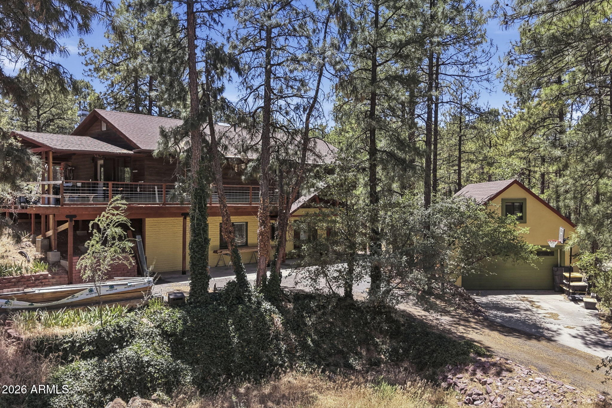 Rare opportunity in a quiet Prescott pines setting in Mountain Club with no HOA, paved roads, private water, and a large .6-acre treed lot just minutes from downtown. This 4-bedroom, 3-bath, 2,618 sq ft two-level walkout ranch offers Saltillo tile, hardwood floors, great natural light, a wood-burning fireplace and stove, central A/C, evap cooling, a covered/wrap-around deck, and flexible space, including main-level in-law quarters plus an office with a separate entrance. Detached 2-car garage includes workspace and full-height attic storage. Near the National Forest and a 10-acre nature preserve. Priced with needed improvements in mind; radiant heat is not currently working. Bring your vision and tools--great setting, space, and upside.