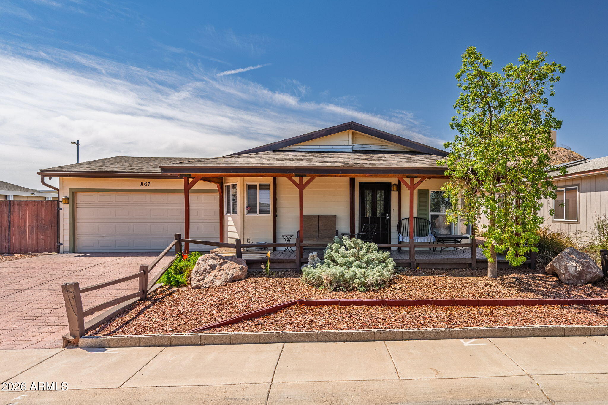 Tucked away in a quiet, well-kept neighborhood with no HOA, this spacious 2,153 sq ft home (measured by professional appraiser) offers character, craftsmanship, and room to truly spread out. All on owned land, not leased land like many manufactured homes in the area.

One of the home's most distinctive features is the custom covered front porch, a true conversation piece lovingly built by the seller's late husband, featuring beautiful wood detailing and a welcoming presence rarely found in the subdivision.

Inside, you'll find an expansive open-concept layout with multiple living areas, warm wood finishes, and a stunning oversized family room featuring extensive custom woodwork and a lodge-style feel full of warmth and personality. Adjacent to the family room is a large storage room offering excellent flexibility and functionality. The family room becomes especially magical during the holidays, a perfect gathering space for Christmas memories, cozy evenings, and entertaining family and friends.

Oak wood flooring adds timeless charm throughout many areas of the home, complemented by wet-friendly floors in others.

The spacious kitchen offers abundant cabinet storage, a pantry, trash compactor, and generous prep space ideal for everyday living and entertaining alike.

The oversized primary suite includes an exceptionally large walk-in closet, while the large laundry room provides extensive storage and workspace rarely found in homes at this price point.

Outside, the backyard showcases beautiful custom rockwork, mature character, and multiple fountain features creating a peaceful outdoor setting with endless potential.

Additional highlights include:
" RV gate and RV hookup including water.
" Large garage with extensive built-in storage, workspace, and natural light
" Spacious flexible floor plan
" Quiet tucked-away location while still close to Casa Grande shopping, dining, and amenities
" Owned land
" All ages welcome

This is not a cookie-cutter property; it is a home filled with craftsmanship, warmth, and unique character that is increasingly hard to find.