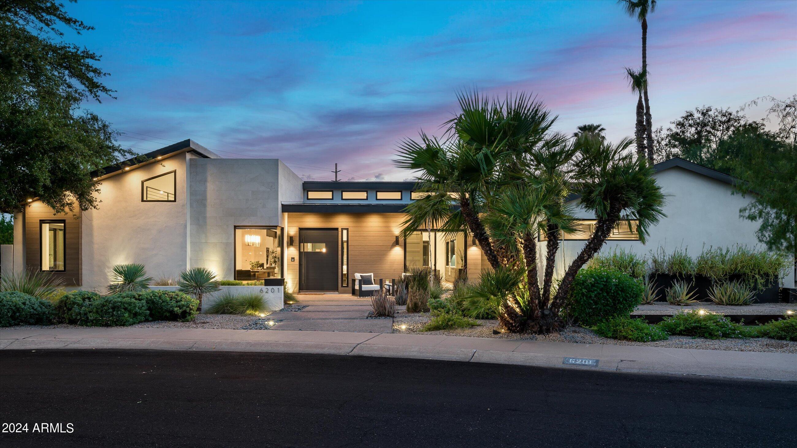 This stunning custom-built modern Arcadia Estate by Blue Sky Homes offers award winning energy efficient and smart home features while situated on a lush green half acre. This home was purposely designed for entertainment in mind with 4 bedrooms, 3.5 baths, a dedicated office, fire place, wine wall, and a rooftop deck with outdoor living rooms in various areas that will exceed the expectations of anyone with the most discerning of taste. Whether you want to entertain inside of the awe-inspiring great room, under the expansive covered patio, under the ramada adjacent to the bluest of blue swimming pools or atop the roof deck with 360° views of Camelback Mountain, Downtown Phoenix and Papago, you've got choices.