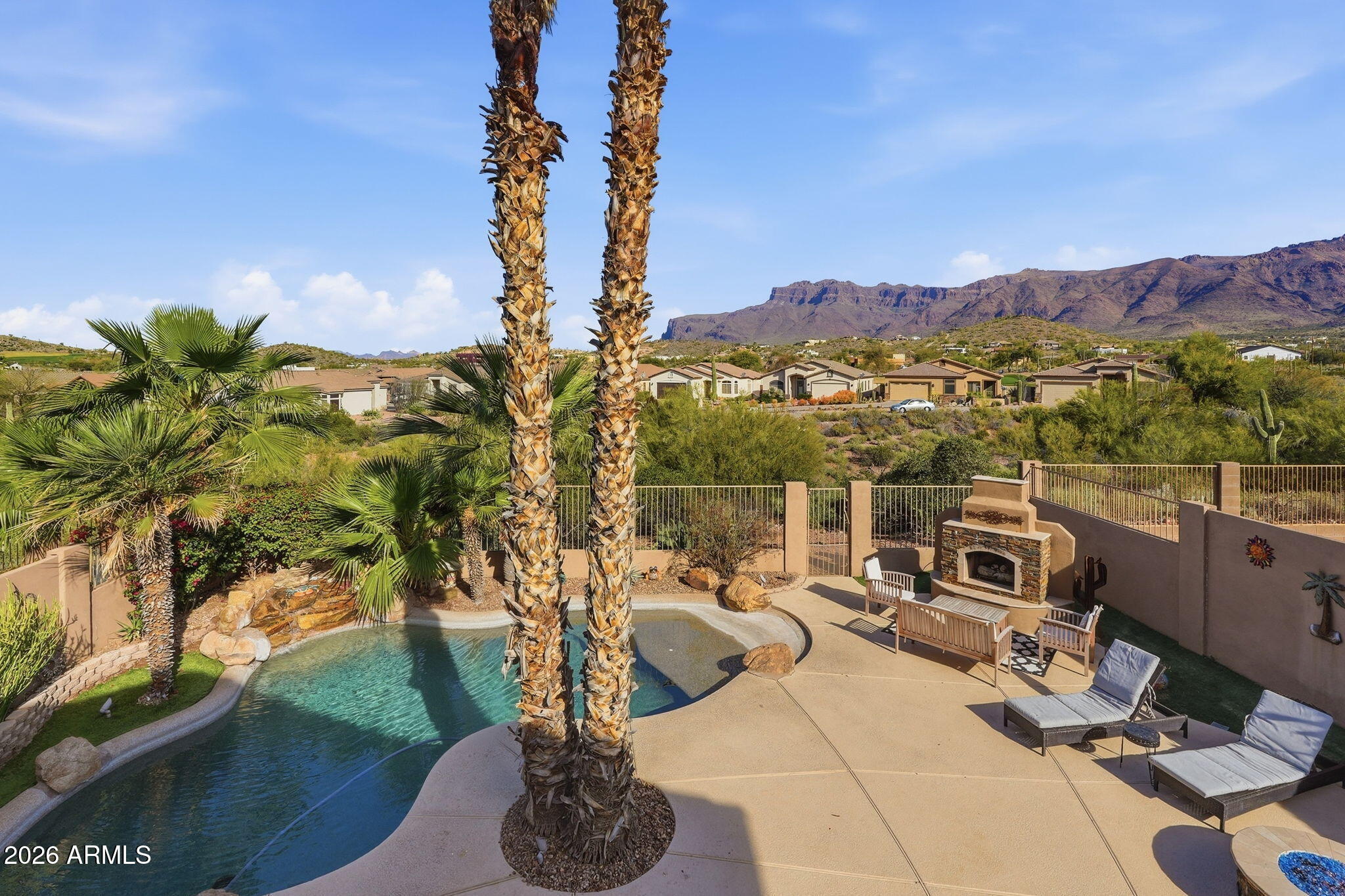 PRICE REDUCED! Panoramic views  of the Superstition and Dinosaur Mountains and wash welcomes you to your private paradise. Complete with Beach walk in heated pool , built in outdoor kitchen ,  gas fire pit, hot tub  and ,fireplace makes this an  entertainers delight Spacious three bedroom home with bedrooms upstairs, The primary bedroom has a walk out deck to sit on overlooking the backyard pool and breathtaking Mountain views. As you enter the home , you will see the amazing yard with views from the patio door and the Kitchen dining area. The kitchen features  granite counters , stainless steel appliances, and bar seating. Large panty in the laundry room. Recently painted outside plus the downstairs.  Storage shed for tools, bikes, etc.  Two car garage with epoxy floors. Low HOA
