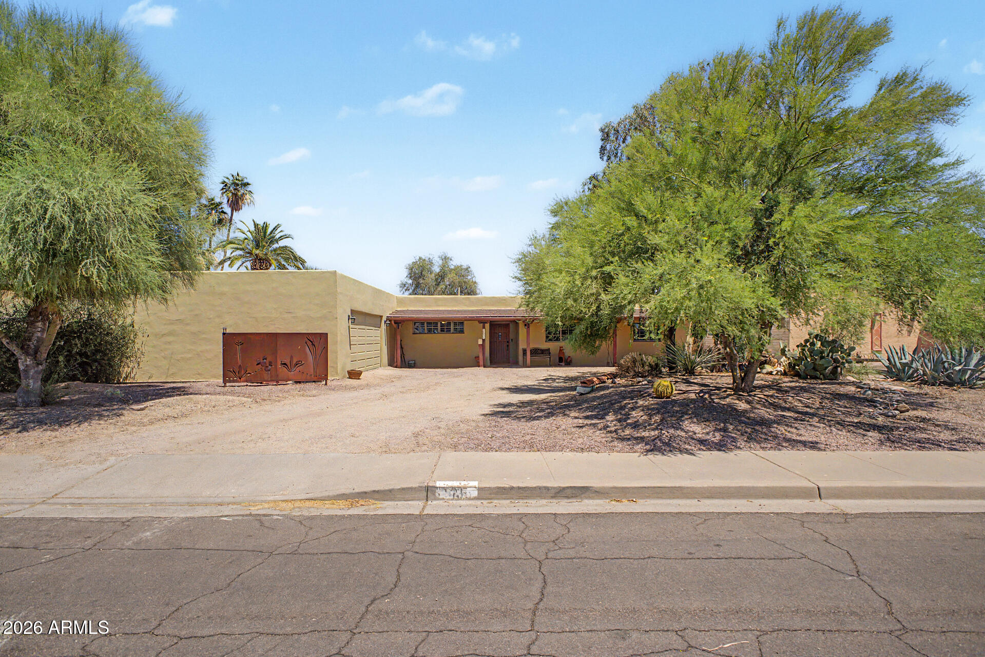 True pride of ownership shows in this classic Territorial-style home on an oversized lot with direct Camelback Mountain views. Step into a spacious, character-rich entryway featuring painted block walls. The living room includes a warm brick fireplace and wood floor inset. A vintage Southwestern dream, the kitchen offers solid wood cabinetry, vibrant tile counters, and a peek-a-boo view of the Praying Monk. The primary suite serves as a peaceful retreat, opening directly to a cozy covered patio. Enjoy a massive backyard canvas with an outdoor fireplace and multiple patios. Don't miss the oversized 2-car garage! Peace of mind with the roof recoated and HVAC replaced in 2022. Not far from Chaparral Park, Old Town restaurants and shopping, top-rated schools, highways, golf, hiking and more!