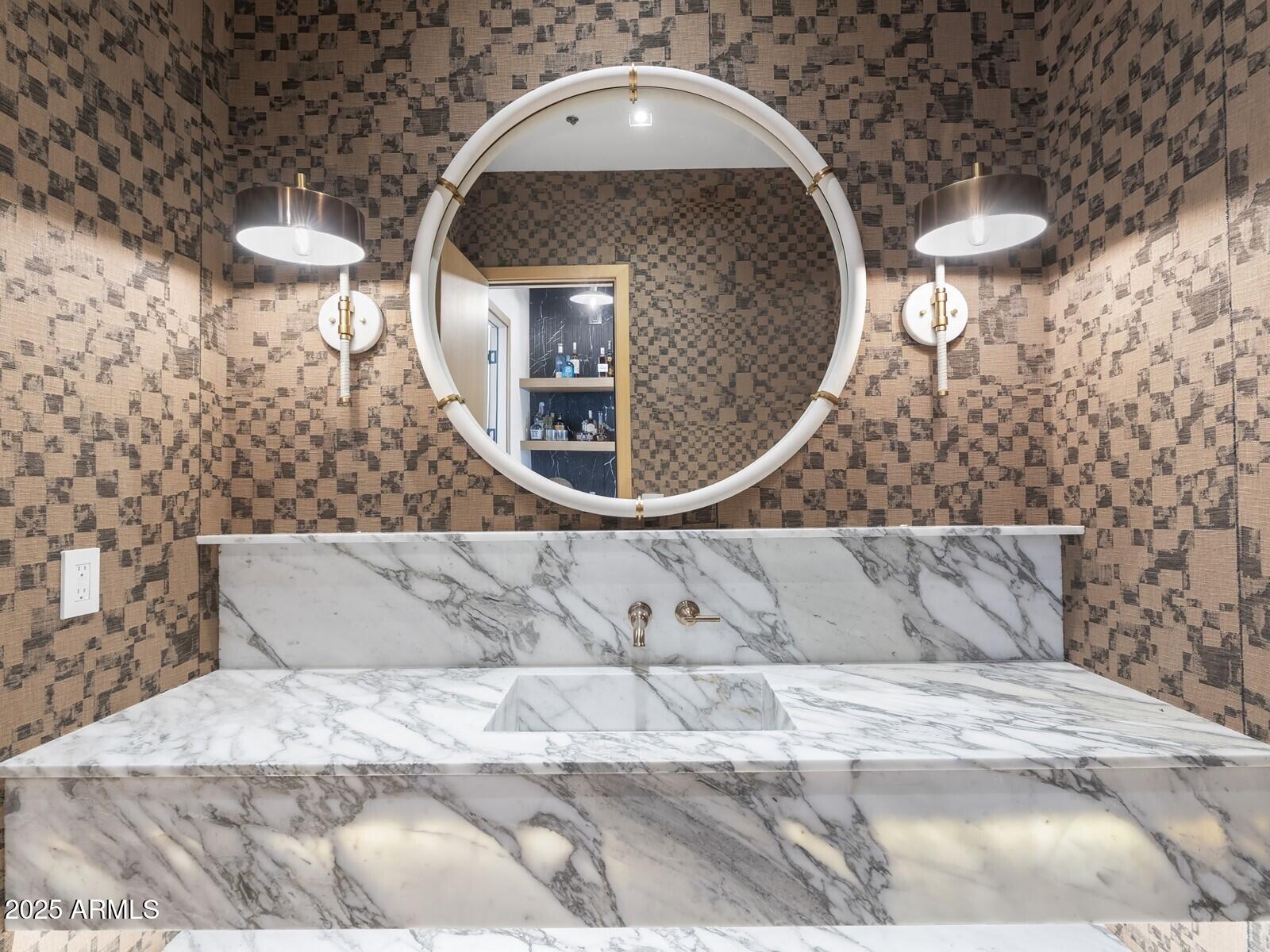Stunning new construction in Paradise Valley, this 6,400 sq ft estate offers 6 bedrooms, 6.5 baths, a home office, and an attached casita. Thoughtfully designed for luxury living, the home features a 45' x 25' infinity pool with integrated spa and cold plunge, a butler's kitchen with oversized pantry, and a 118-bottle wine room. The chef's kitchen and butler's pantry showcase custom cabinetry and high-end finishes, blending elegance with functionality. The primary suite is a private retreat with a custom Isokern fireplace, dual water closets, custom marble bathtub, separate his-and-her walk-in closets with integrated washer/dryer, and a serene zen garden with outdoor shower. Expansive glass doors create seamless indoor-outdoor living with stunning Camelback Mountain views. See More & Vide Mature trees, resort-style landscaping, and exquisite craftsmanship make this a rare opportunity to own one of Paradise Valley's most remarkable new builds.