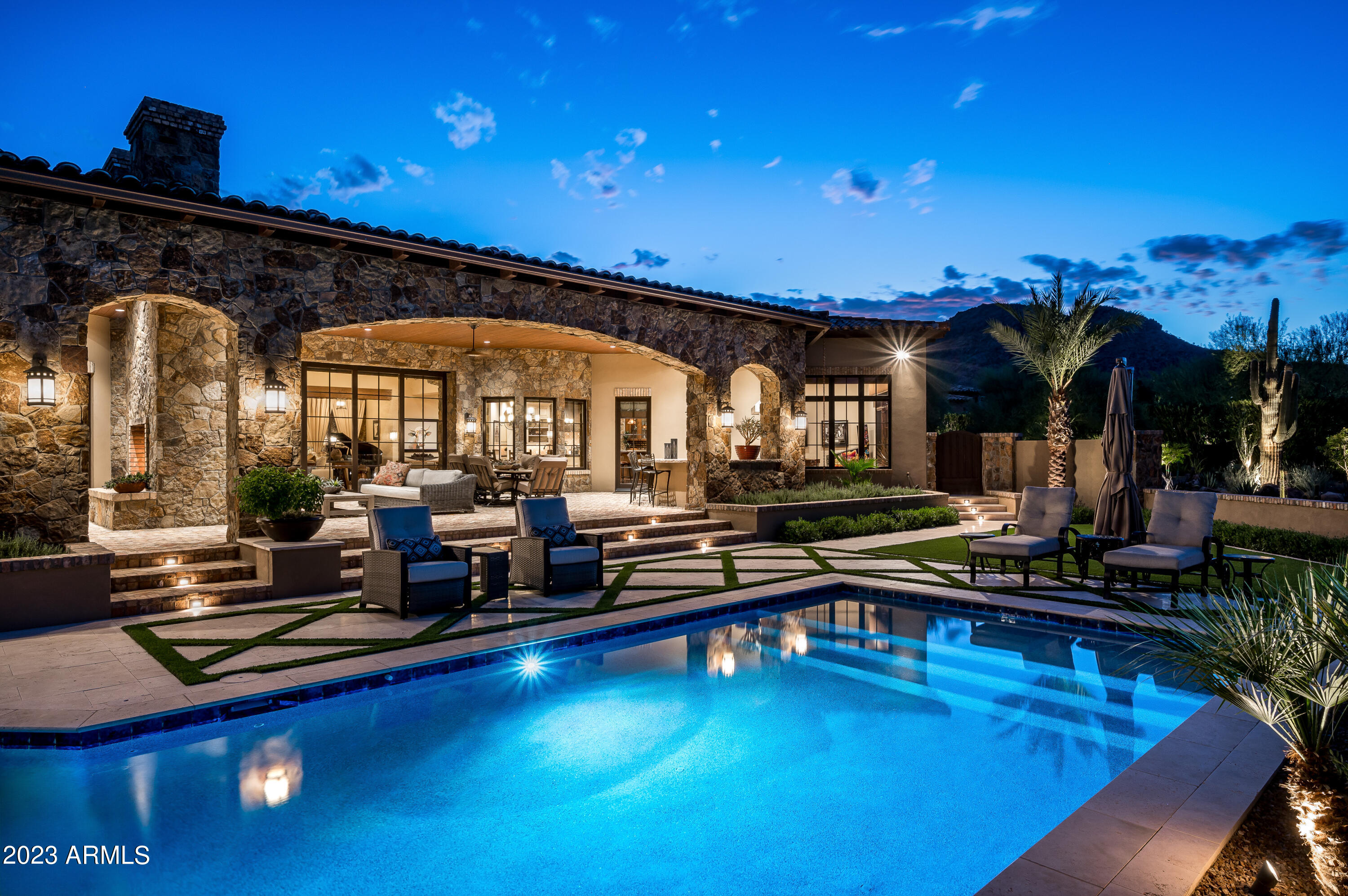 Rare opportunity in Paradise Valley. This immaculate single level estate by Calvis Wyant Luxury Homes is one not to be missed. Upon arrival through the front gate, the sense of privacy and security is evident, and the welcoming front courtyard entry with charming fireplace sitting area sets the stage for what's to come. The home flows seamlessly from the open great room floorplan with automatic pocket doors to the spacious outdoor living areas, while the recently updated pool/spa and lush desert landscaping and private walking path on the 1.31 acre property is reminiscent of the Desert Botanical Gardens. Features include a well appointed and spacious kitchen, multiple eating areas, custom bar and game room for entertaining, temperature controlled wine room, large primary suite, three en-suite bedrooms (including a separate guest casita), private office (or fifth bedroom), exercise room, expansive pantry and laundry/utility room, and an oversized 5+ car garage with abundant space and storage. This home is the embodiment of the Arizona lifestyle that is in such high demand. Do not miss out!