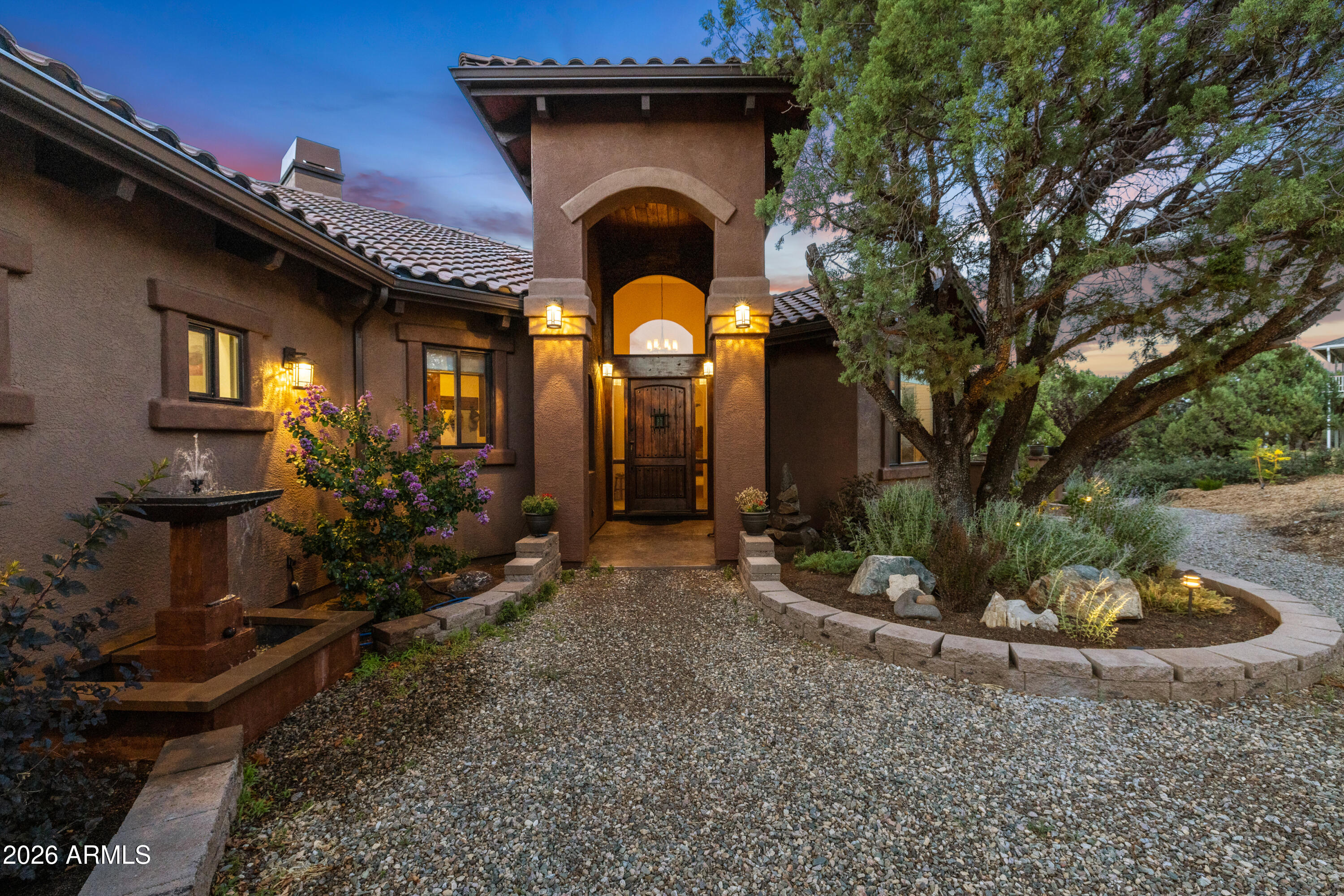 Perched on 1.37 acres high above Prescott, this custom-built residence was thoughtfully designed to capture some of the most breathtaking panoramic views in the region. From the expansive covered deck, take in unobstructed vistas stretching from Thumb Butte and Granite Mountain to the distant San Francisco Peaks, with the sparkling city lights of Prescott unfolding below.

The main level features a highly functional split floor plan, offering both a luxurious primary suite and a private secondary en suite, thoughtfully separated by an open-concept living and kitchen area. The chef's kitchen is as beautiful as it is practical, showcasing rich knotty alder cabinetry, chisel-edge granite countertops, and a breakfast bar framed by a sunlit enclave of windows-- perfect for enjoying serene mornin
The lower level is equally impressive, with stamped concrete flooring throughout and generous space for relaxation and entertainment. Here you'll find a spacious family room, an inviting wet bar, a dedicated game or hobby room, and a third bedroom. Step outside to the covered patio, where the remarkable views continue uninterrupted.

Multiple outdoor living spaces, enhanced by carefully designed patios and tranquil water features, create a private sanctuary that feels worlds away. Completing the property is an oversized three-car garage and full RV hookups, offering both convenience and versatility.

This exceptional home is a rare opportunity to experience elevated living, where refined design meets awe-inspiring natural beauty.