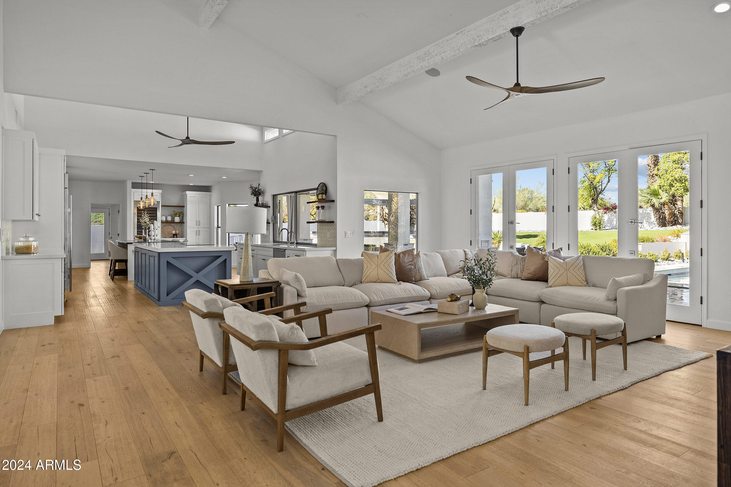 Situated atop an elevated lot, refined soft contemporary finishes abound in this Cactus Corridor masterpiece. Elements of the original 1980s open concept give this home a special character the moment you step foot through the twelve foot front doors into the welcoming foyer. Tasteful light wood floors take you to the massive living room with soaring ceilings, multiple exits to the backyard and fireplace.  The double island kitchen is a chef's dream with built-in refrigerators and a coffee bar. The dining area is fit for the grandest of gatherings and is highlighted by additional seating areas and/or play areas beyond. Outside, the backyard has all of the perks, with a massive diving pool, sport court, kitchen, fire pit and ample room to entertain.