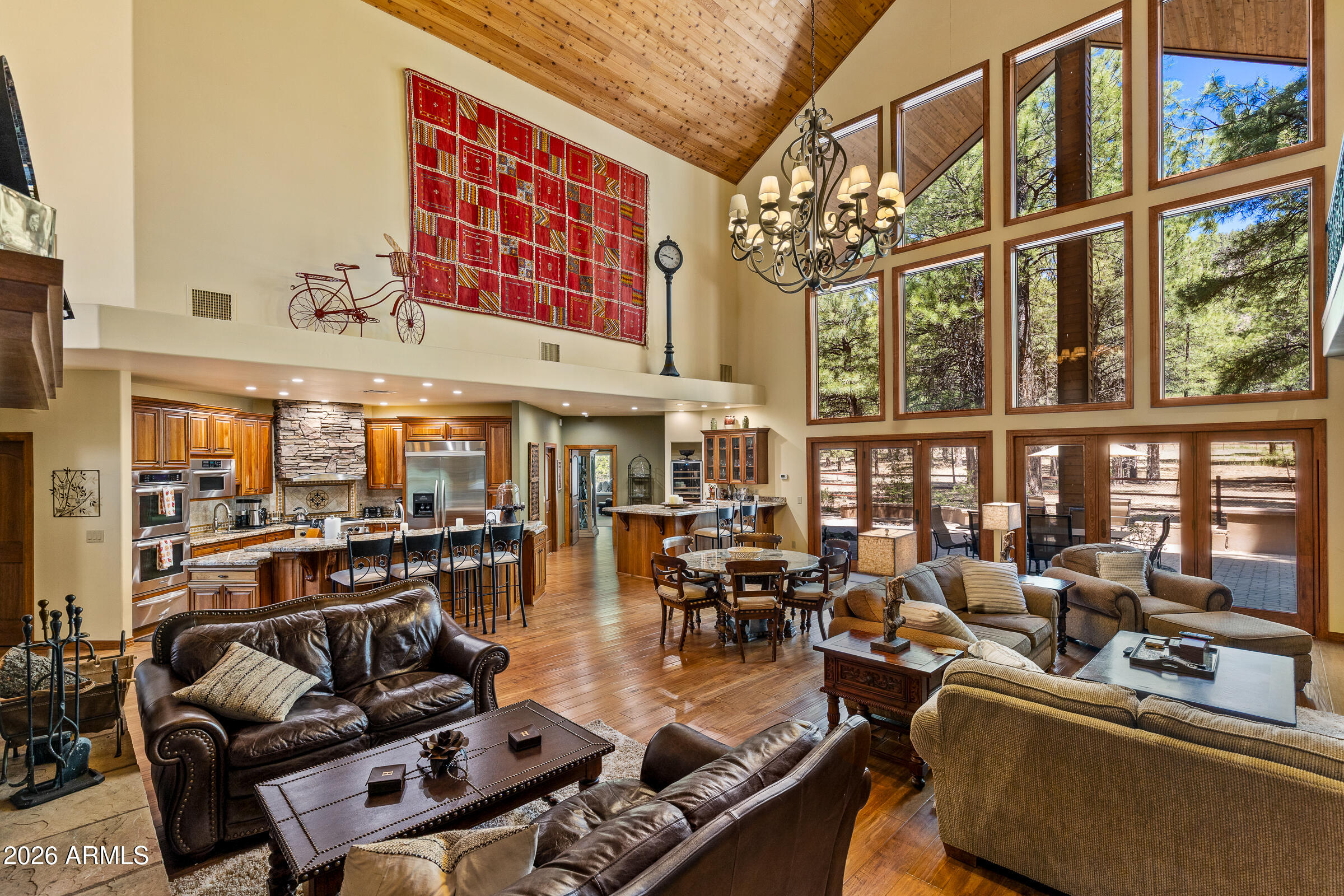 Offered by the original owners, this 5,009-sq-ft mountain retreat on over two forested acres in Lockett Ranches embodies quiet luxury and old-world craftsmanship. Soaring ceilings and massive windows flood the layout with natural light, highlighting rich stone details. Featuring four bedrooms, five bathrooms, two offices, a 4-car garage with workbench, private theater, game room, cedar-lined sauna, and large gym, the home is ideal for both entertaining and remote work. Outside, enjoy direct access to forest trails and Buffalo Park. Despite its grand scale and absolute privacy, this lock-and-leave sanctuary delivers surprisingly low utility costs and manageable upkeep, remaining just minutes from Flagstaff's premier skiing, hiking, golf, dining, and city amenities.
