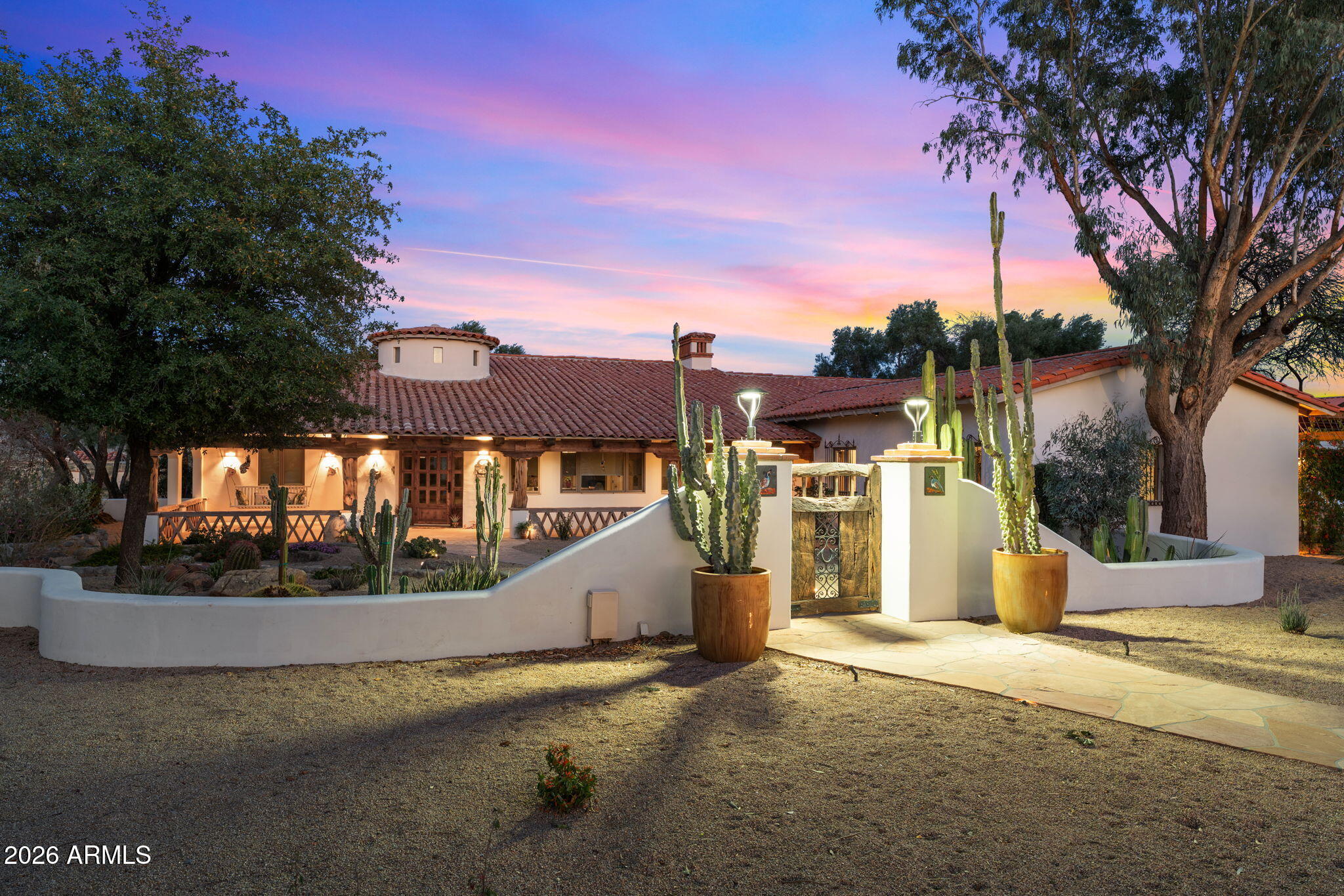 Experience a truly once-in-a-lifetime opportunity to own an extraordinary Spanish-style horse ranch set on 43 breathtaking acres overlooking Martinez Wash in Wickenburg, Arizona! Properties of this caliber - combining architectural beauty, privacy, and a fully equipped equestrian setup - rarely come to market. The 4,027 sq. ft. main ranch residence captures the timeless elegance of classic Spanish design. Inside, you'll find rich tile flooring, solid Spanish-style wood doors, iron window valances, and soaring over height ceilings with exposed wood beams that create warmth and character throughout the home. The showstopping kitchen is truly the heart of the home, featuring a massive island, stunning granite countertops, custom cabinetry, tile backsplash, walk-in pantry, and high-end and high-end appliances - perfect for entertaining or everyday luxury living. The spacious layout includes 4 bedrooms, 3.5 bathrooms, multiple flex spaces, and two inviting fireplaces that add comfort and charm. Guests and extended family are welcomed with two beautifully designed residences. A 613 sq. ft. casita offers 1 bedroom and 1 bathroom, while the 800 sq. ft. guest house includes 2 bedrooms and 1 bathroom. Both feature fully equipped kitchens, stylish bathrooms, and comfortable living spaces, making them ideal for visitors, caretakers, or potential rental opportunities. Step outside and the magic of this ranch truly unfolds. The grounds feel like a private desert resort, complete with expansive slab rock patios, massive wood posts, lush grass courtyards framed by stucco walls, a peaceful fountain, and a sparkling swimming pool. Enjoy Arizona sunsets surrounded by mature citrus and eucalyptus trees, striking desert landscaping, and towering cacti. Outdoor living is elevated with a fully equipped outdoor kitchen, tranquil pond, and a classic functioning windmill that adds authentic ranch character. The property is equally impressive for its infrastructure and utility. There are multiple garages and carports providing over 15 parking and storage spaces, full RV hookup, plus a 2,604 sq. ft. workshop featuring an office and bathroom, perfect for projects, equipment, or business use. For equestrian enthusiasts, the ranch offers a well-designed horse facility that includes a riding arena, covered corrals, stall, tack room, hot walker, hay storage, automatic waterers, and irrigated horse pastures. Even better, the property borders public land, providing endless riding opportunities directly from your ranch onto miles of scenic desert trails. With unmatched views, classic Spanish architecture, exceptional outdoor living spaces, and a fully functional horse setup, this remarkable Wickenburg ranch embodies the very best of Arizona's western lifestyle. A rare offering where luxury living and authentic ranch life come together in perfect harmony.