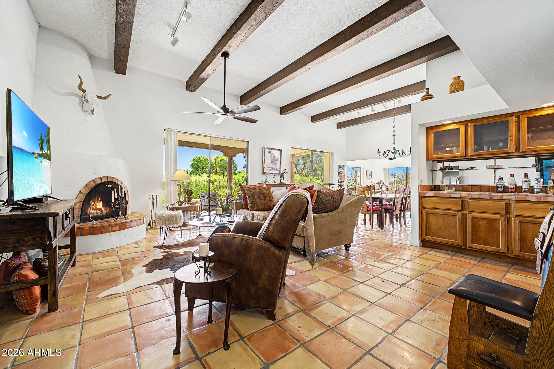 Set on a meticulously maintained cul-de-sac lot overlooking the 2nd green of the White Wing golf course, this home captures both charm and magnificent mountain views with soaring ceilings, wood beams, and a striking fireplace as its centerpiece. The expansive paved patio takes full advantage of the pie-shaped lot, offering front row views of the golf course and the breathtaking Four Peaks beyond. Located within Rio Verde Country Club, residents enjoy a resort lifestyle with two championship golf courses, practice facilities, a fitness center, heated pool and spa, tennis, pickleball, bocce, vibrant clubhouse dining and social spaces, plus art studios, game rooms, and scenic desert trails. Come experience it for yourself before the opportunity passes.