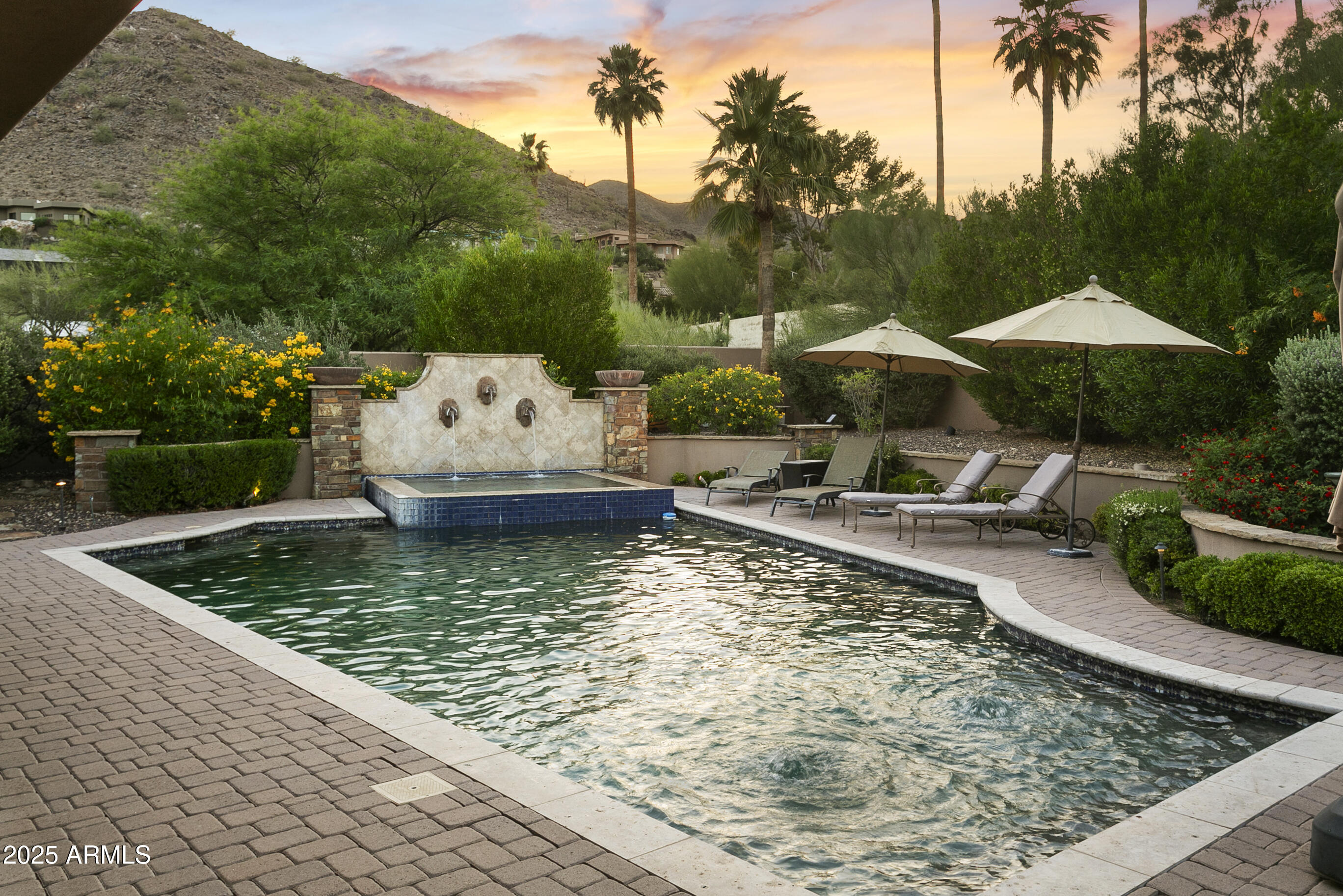 Privately gated and elevated on nearly 1.6 acres, this quintessential Paradise Valley estate greets you with sweeping mountain views from every angle. Tastefully updated, it evokes classic Arizona resort living with the warmth of hacienda charm. From the custom iron and glass entry, you'll find a home that is equally comfortable, effortless to manage, and ideal for entertaining. Every detail invites you to unwind -- the open kitchen, oversized wine bar, dining room with Camelback views, and expansive patio that opens to a lush, private oasis backyard. A detached guest house welcomes your loved ones in style. An owned solar system keeps energy costs remarkably low, with total electric bills under $2,000 last year. This is the one.