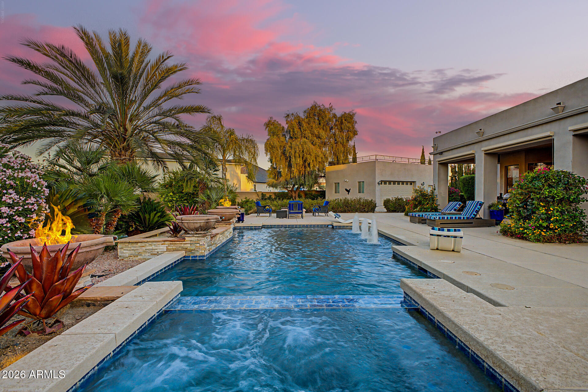 Set on over an acre in a quiet cul-de-sac, this 3 bedroom, 3.5 bathroom home offers an impressive 5.5-car garage capacity and showcases sweeping views of the Superstition and San Tan Mountains. From the moment you arrive, the inviting courtyard and custom glass-and-iron entry set a warm, welcoming tone. Inside, natural light fills the space, highlighting elegant stone flooring, detailed ceiling accents, and open living areas designed for both comfort and entertaining. The primary suite is a peaceful retreat, complete with a cozy sitting area, a spa-like bath with dual vanities, a soaking tub, and a spacious closet, along with direct access to the backyard oasis. Each bedroom features its own private ensuite bathroom, offering comfort and privacy for all. The kitchen blends function and style with rich wood cabinetry, beautiful granite surfaces, stainless steel appliances, and a large island ideal for gathering. The resort-style backyard is a true standout, featuring a heated pebble-tech saltwater pool and spa with fire and water features, plus an extended patio prepped for a future outdoor kitchen. The expansive yard is fully landscaped with a rose garden, six mature fruit trees, and plenty of open lawn space. Adding even more versatility, the property includes an additional 2.5-car detached garage with a rooftop view deck on top--perfect for enjoying the surrounding mountain views. The detached garage is also equipped with 220-volt wiring, making it ideal for a workshop, hobbies, or additional equipment. With ample space for parking, storage, and entertaining, plus convenient access to dining, shopping, and freeways, this home is truly one of a kind!