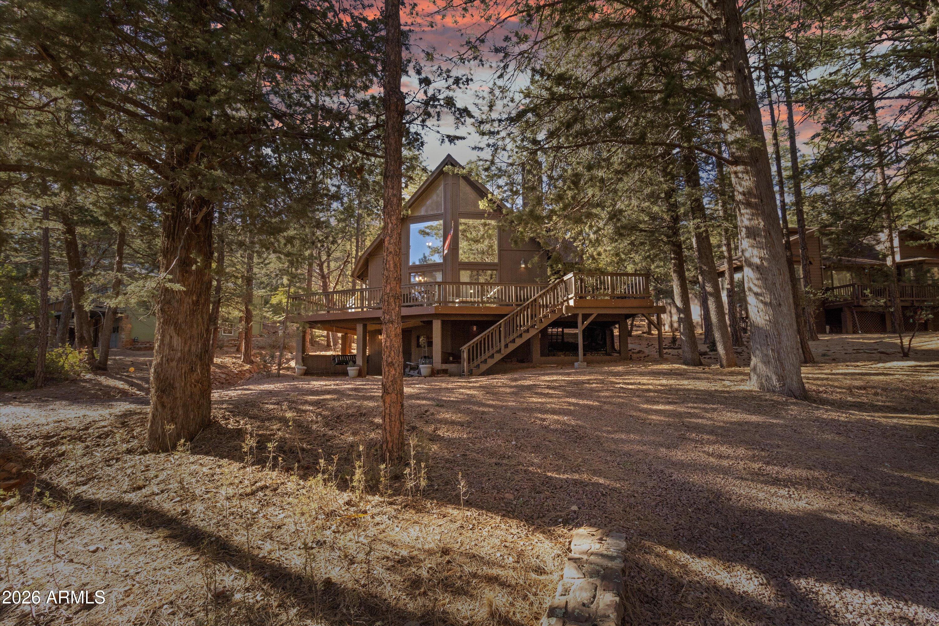 This stunning mountain cabin offers sweeping views of the surrounding mountains, framed by large chalet windows that flood the home with natural light. With sliders on both sides, the cabin opens to a spacious, wrap-around Trex deck, perfect for outdoor relaxation and entertaining. The main level features newly installed luxury vinyl flooring, while the bedrooms and downstairs area boast plush new carpeting for added comfort. The recently updated kitchen is a chef's dream, featuring beautiful granite countertops, stainless steel appliances, and stylish new lighting and fans throughout. The large open floor plan creates a seamless flow between the living and dining areas, anchored by a cozy wood-burning fireplace ideal for cozy evenings. A versatile loft space, located just outside the master suite, can serve as an office or an additional sleeping area, offering flexibility for your needs. The master suite is a peaceful retreat with its own private balcony, perfect for morning coffee or stargazing at night. The walk-out basement expands your living space with a pellet stove for warmth and an area for laundry, making it a great spot for extra relaxation or hobbies. Surrounded by tall trees, this cabin offers the ultimate mountain retreat experience, providing both seclusion and tranquility. Whether you're enjoying the natural beauty from the deck or cozying up by the fireplace, this cabin is the perfect place to escape and unwind. Don't miss out on this incredible opportunity to own a piece of mountain paradise