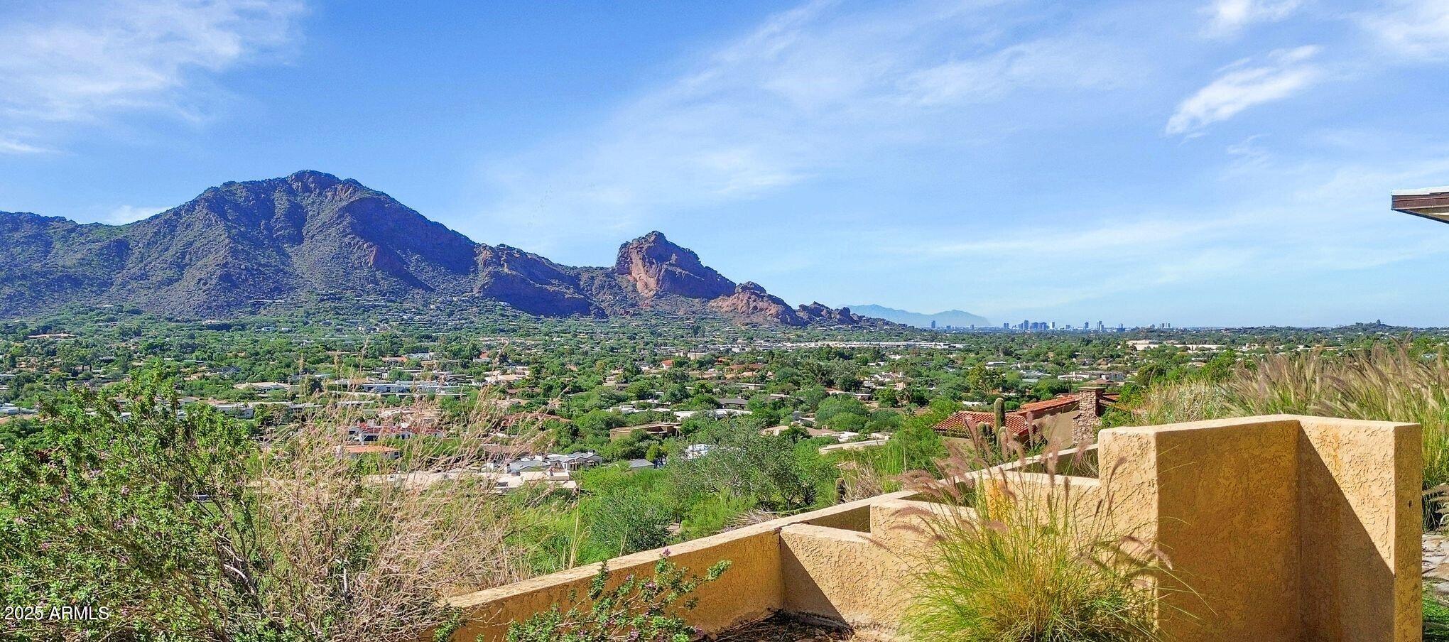 An exceptional opportunity awaits on this exclusive 3.88-acre premium view lot—a rare combination of privacy, space, and unparalleled views. Perched in a serene hillside setting surrounded by natural desert beauty, this property features a flat building pad offering endless possibilities to remodel the existing residence or create your dream estate from the ground up. Enjoy breathtaking panoramic views of Camelback Mountain, the sparkling city lights, and sweeping valley scenery from sunrise to sunset. This is a truly special homesite—a private retreat that captures the essence of luxury desert living, blending tranquility, prestige, and awe-inspiring scenery in one remarkable setting.