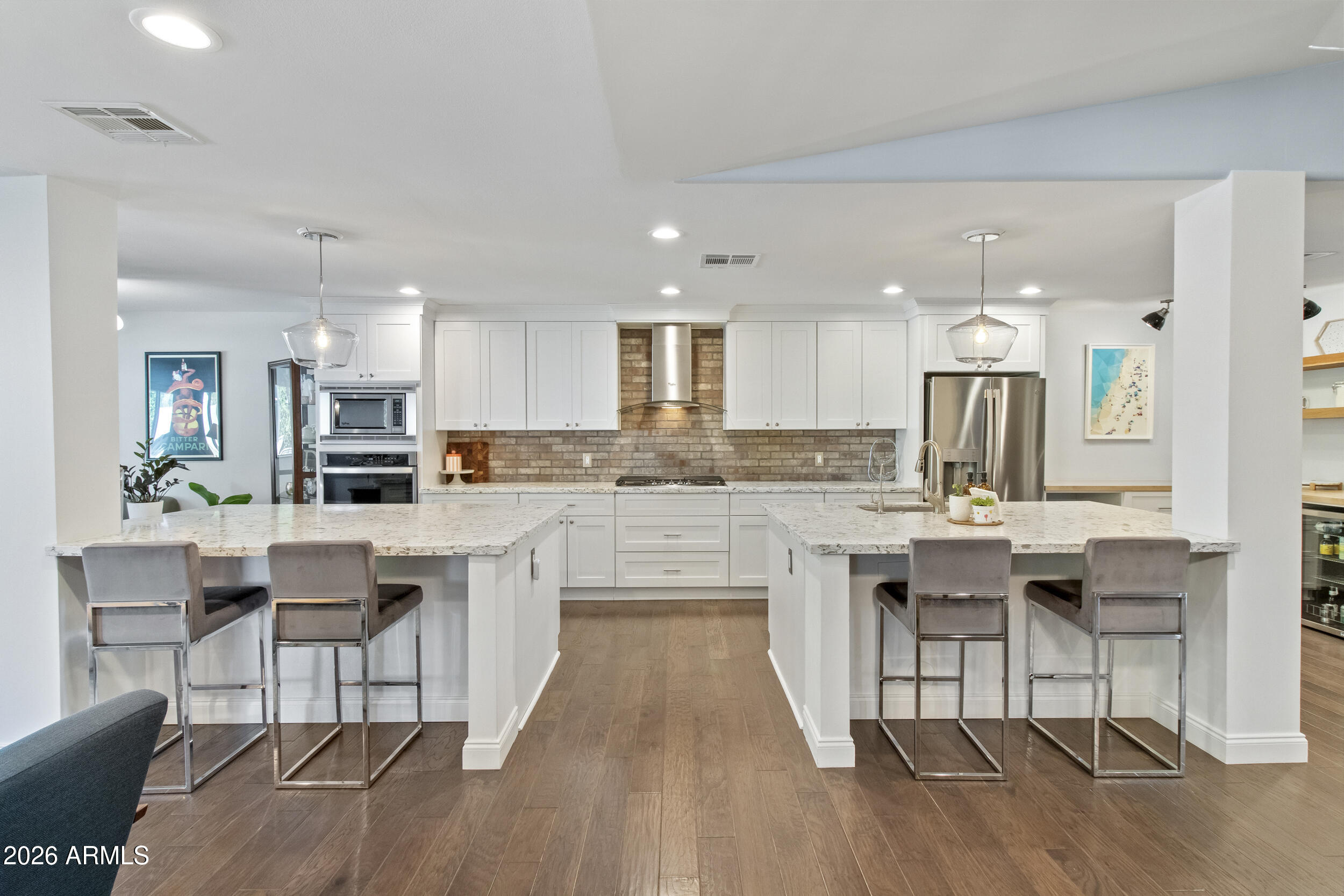 Arcadia turnkey under $1.75M. Fully renovated single-level home in the heart of Arcadia featuring 4 bedrooms, 2.5 baths, a dedicated office, and 2,842 square feet on a 10,520-square-foot lot. Located within the highly sought-after Scottsdale Unified School District and zoned for Tavan Elementary, Ingleside Middle School, and Arcadia High School.

Designed for both entertaining and everyday living, the heart of the home is a chef's kitchen featuring two oversized quartz islands, custom shaker cabinetry, stainless steel appliances, a brick backsplash, and a spacious walk-in pantry. The open-concept floor plan flows seamlessly into the dining and living spaces, highlighted by vaulted beam ceilings, hardwood floors throughout, abundant natural light, and French doors that create a true indoor-outdoor lifestyle.

The owner's suite serves as a private retreat with a vaulted ceiling, brick gas fireplace, custom walk-in closet, and a beautifully updated marble bath featuring dual vanities and a walk-in shower with bench seating.

The resort-style backyard was thoughtfully redesigned for Arizona living and includes a saltwater PebbleTec pool and spa, travertine decking, a fully covered pitched-roof ramada with timber beams and ceiling fans, mature landscaping, custom lighting, privacy enhancements, and multiple areas for relaxing and entertaining. Premium exterior improvements include pavers, custom steel edging, mature olive and lime trees, updated irrigation, and raised block walls creating a truly private setting.

Recent upgrades include dual variable-speed HVAC systems (2022 and 2024), roof replacement in 2022, Simonton dual-pane windows, full-home water filtration and softener system, custom mudroom and pantry build-outs, rain gutters, and a hard-wired LiftMaster smart garage system.

Backing directly to the Greenbelt, the property offers exceptional privacy while providing immediate access to walking and biking paths that connect to some of Arcadia's most popular restaurants, coffee shops, parks, and entertainment destinations. A rare opportunity to own a move-in-ready Arcadia home that combines thoughtful design, extensive upgrades, and one of the neighborhood's most desirable lifestyle locations.
