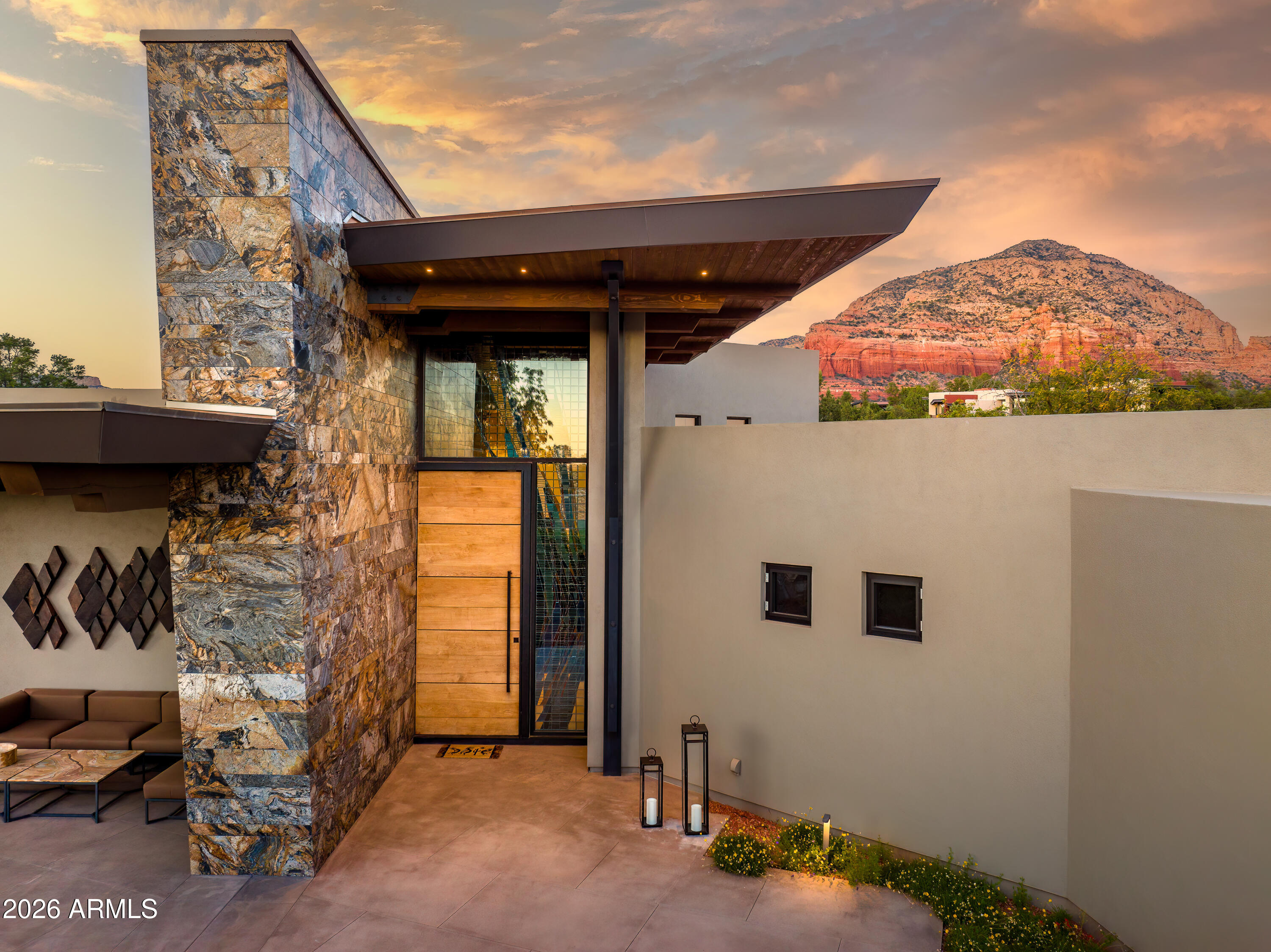 Introducing an exquisite 5-acre retreat with unparalleled elegance, 120 Paisano Road is the pinnacle of luxury in Sedona, Arizona. With a total of 9,113 square feet of meticulously crafted living space, this one-of-a-kind property consists of 3 private homes, 6 bedrooms, 9 bathrooms. Tucked away at the end of a secluded, private road, you'll revel in the utmost privacy while being just moments away from the heart of Sedona. The three homes are fully integrated with a custom Savant home automation system, including 22 music zones, 8 video zones, 151 lighting zones and 30 motorized shades, all easily controlled by the click of your phone or tablet. Completed in 2018, this modern luxury estate showcases the utmost quality craftsmanship and finishes. The definition of World Class! The main house spans 5,739 square feet with breathtaking panoramic views from every room. A floor to ceiling, stained glass art installation, by Bob Berg surrounding the massive pivot hinged entry door greets your guests upon arrival. A grand stone entry wall that flows from the exterior to the interior is stunning. The Kitchen is an entertainer's dream, adorned with custom finishes, materials and top of the line appliances. The spacious, open floor plan, towering ceilings, exposed beam architecture, and magnificent architectural fireplace accentuate the Living and Dining spaces. Porcelain tiles, imported from Italy are throughout the main level, equipped with radiant heating.

The main home was designed with 3 ensuite bedrooms, currently configured as a Primary Suite, Office, and Gym, complete the main level. The Primary Suite is elegant and the perfect place to relax and soak in the red rock views of Boynton Canyon while the bathroom provides a spa-like experience. The large walk-in closet features a built-in refrigerator and washer/dryer. Both Gym and Office Bathrooms and Closets have custom casework, and top of the line finishes. The "Gym" Bathroom also features a large custom sauna.

Downstairs, you will enjoy an incredible home cinema by Tech Integrated, featuring a state of the art, Meyer Sound system, not available to consumers. This is the same reference sound that is used in Hollywood movie soundtracks including Skywalker, Pixar, 20th Century Fox and Warner Bros. Meyer Sound engineers were flown in from Berkeley to calibrate the system and certify the only EXP Cinema in Sedona! Beyond the theater, you'll fall in love with the gorgeous wine cellar, cocktail lounge, and beer alcove with custom, temperature-controlled wine storage for 1000+ bottles with state-of-the-art lighting. Full wet bar with top tier finishes and appliances including refrigerated drawers, ice maker, integrated kegerator, and dishwasher. All curated to provide the most eloquent experience. The Verde Valley (20 minutes away) was declared an American Viticultural Area (AVA) with a booming wine scene and over 20 amazing tasting rooms/wineries.

The Guest House spans 1,305 square feet with 2 luxurious ensuite Bedrooms, a full Kitchen, inviting Dining area, and a Living Room adorned with a custom steel surround gas fireplace. A private terrace provides the ideal setting for quiet contemplation overlooking the private horse arena. 

Embodying sophistication and luxury at every turn, welcome to the "Playhouse". Originally an art studio belonging to renowned cowboy artist legend, Joe Beeler. This space pays homage to its past while embracing modern luxury with 2,069 square feet of entertaining space and 1,000+ square feet of covered terrace. The Playhouse features a full bathroom and a half bathroom, along with an array of playful spaces, including a pool table room, ping pong table room, Kitchen, and Lounge (Do not miss the hidden vault, safe room). Step outside the Playhouse and experience opulent outdoor living. The professional-grade tennis court and practice court, invite you and your guests to engage in spirited matches amidst breathtaking red rock surroundings. Gather around the gas fire pit, perfect for creating cherished memories under the starlit, world famous, dark sky city of Sedona. Note: this building could easily be reconfigured as a 2 or even 3-bedroom residence.

This is truly the most spectacular estate on the market in Sedona and the opportunities are endless. With three private residences, and ample space for entertainment, you could host a beautiful wedding, private event, or retreat. The proximity to world class golf, horseback riding, mountain biking, hiking, off road trails, fly fishing, and a myriad of outdoor activities are literally right outside your door. Located just minutes from the luxurious Enchantment Resort and Seven Canyons Country Club where scenic golfing and 5-star dining await!

You must walk this stunning in person to truly experience the magnitude of this estate!