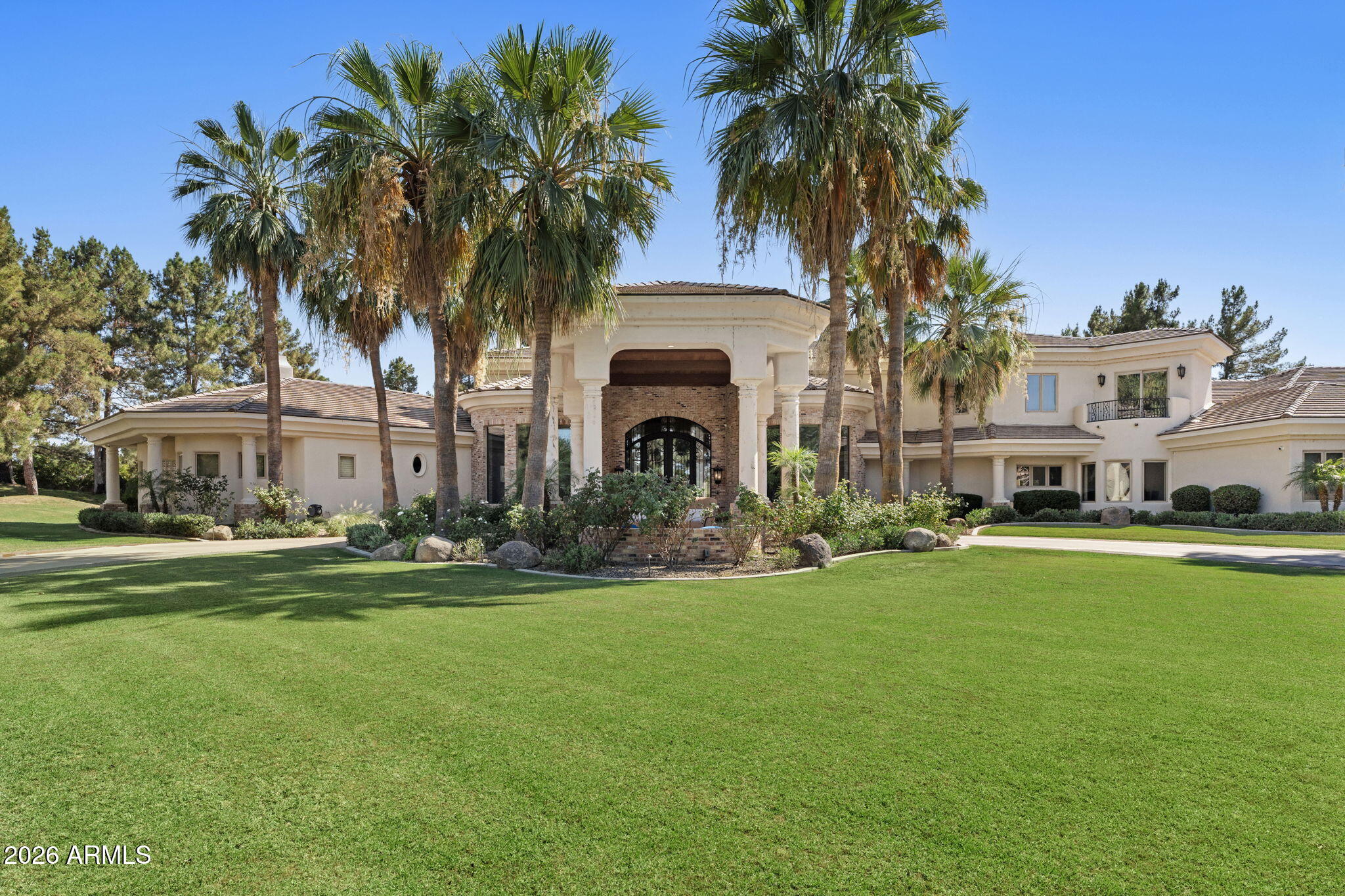 A rare opportunity to own one of Chandler's most impressive custom estates - nestled on a 1.7 acre lot within the prestigious gated enclave of Oakwood Hills, this exceptional property offers 9,227 square feet of luxury living featuring 5 bedrooms, 6.5 bathrooms, an 8-car garage, w/ a private guest house complete with a kitchenette, walk-in closet, and full bath. Designed for both everyday living and grand-scale entertaining, the home showcases exquisite craftsmanship and timeless elegance throughout. The spacious primary suite serves as a private retreat with dual vanities, separate his-and-her closets, and direct access to the resort-style backyard. Multiple living and entertaining spaces include a spectacular family room with a wet bar and pocket doors that seamlessly blend indoor and outdoor living. The exterior is truly breathtaking -  a circular driveway w/ grand portico and impressive iron entry doors create unforgettable curb appeal. The fully fenced backyard is a private resort featuring lush landscaping, dual swimming pools, spa, rock waterslide & grotto, expansive patio with misters, and multiple gathering areas designed for year-round enjoyment. Extensive recent upgrades make this estate completely move-in ready including a new roof, new AC units, all-new pool equipment, resurfaced PebbleTec pool finish, new pavers and cool decking, new home automation system (control 4), new theater screen and sound system, electric shades inside and out, cedar-covered ceilings on the front portico and rear patio, new landscape lighting, additional garage storage, wood flooring, and new carpet throughout the upper level and basement. Beyond the home itself, Oakwood Hills offers a lifestyle unlike any other in Chandler. This private, upscale community features only 33 custom homesites all situated on one-acre+ lots along with a private lake and gated entry. Combining privacy, prestige, and unparalleled amenities, this is truly one of Chandler's most coveted neighborhoods.