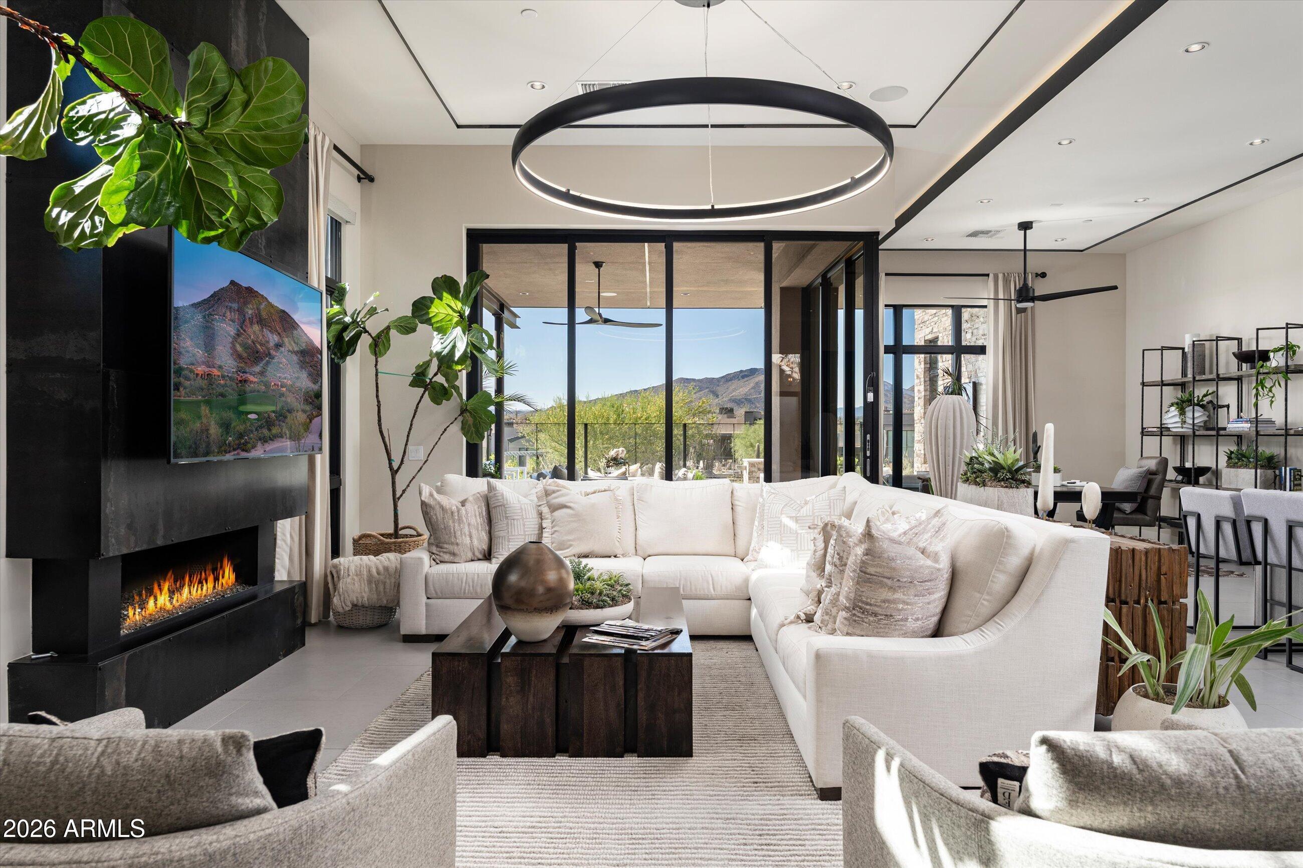 Full Golf Membership available with this stunning, fully furnished contemporary villa in Desert Mountain's coveted Seven community. Built by Camelot Homes and overlooking the 12th fairway, this architectural masterpiece showcases a highly sought-after floor plan designed to maximize seamless indoor-outdoor living, exceptional guest accommodations, and breathtaking mountain vistas with spectacular Arizona sunsets. The light-filled great room opens effortlessly through fully retractable pocketing glass doors to an extraordinary outdoor retreat featuring an expansive covered patio, built-in BBQ island, gas fire pit, outdoor television, heated spool, and private putting green--creating the ultimate setting for entertaining or relaxing year-round. The luxurious primary suite offers a spacious. bedroom, spa-inspired bath, and generous custom closet. A comfortable guest suite and a separate-entry casita with two private guest bedrooms provide exceptional privacy and flexibility for family and friends. Thoughtfully appointed with premium finishes throughout, the home features dual kitchen islands, Wolf and Sub-Zero appliances, designer lighting, smart home technology, and impeccable craftsmanship at every turn. With no interior steps and a true lock-and-leave lifestyle, this exceptional residence offers effortless luxury in one of Desert Mountain's most desirable communities.