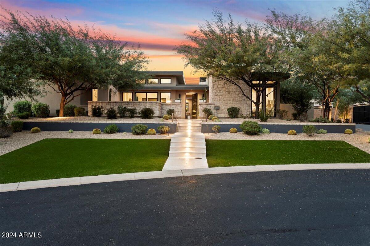 Discover White Horse, luxury living North Scottsdale. Breathtaking single level retreat is simply defined in one word; perfection. As you arrive to the exclusive gated community White Horse, you feel nature in harmony with mountain back drop and city lights. As you begin you experience of Dessert Gem, the courtyard offers an enchanting spa like energy, vestibule with fireplace/sitting area and water feature which delivers you to the glass living space and heart of the home. It is a breathtaking experience with floor-to-ceiling sliding glass doors, a second water feature, and a temperature-controlled wine showcase which feels like art. The home was Designed to seamlessly blend indoor and outdoor living, the great room features a stoned fireplace and opens to an outdoor gallery with a cover tongue-and-groove roof and an additional fireplace. The gourmet kitchen boasts a sprawling quartz island, Viking commercial range, and accordion windows opening to a front entertaining courtyard. The primary suite is a private haven with views of water features, a coffee bar, dual closets, separate vanities, and a walk-in shower. The secondary wing includes three generous ensuite bedrooms, a bonus flex media room, and an enormous laundry room. Outdoors, indulge in a negative edge pool, spa, sunken firepit, putting green, and two fully equity built-in BBQ areas with a smoker and pizza over! Separate guest quarters (detached) offers a kitchen, pool bath, and additional entertainment space. This residence is a meticulously crafted haven, where every detail enhances the luxurious lifestyle offered in the heart of 85255.