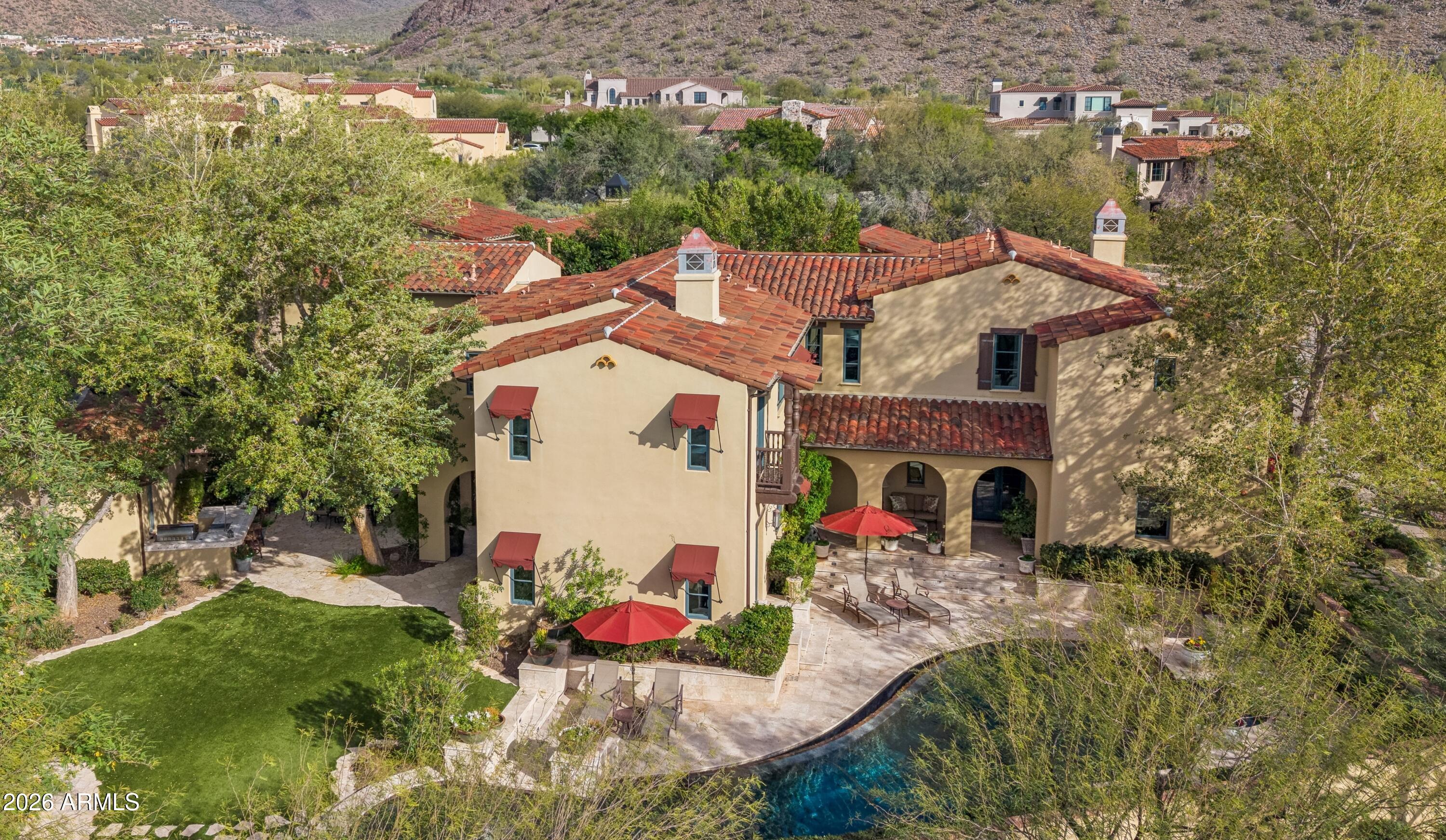 Located in the premier enclave of The Parks of Silverleaf this 5,844 square foot Verandah is nicely situated on a corner lot which provides natural open space and mountain views. The charming Spanish Colonial home features 5 bedrooms with walk-in closets, 4.5 bathrooms, office located off the master that could also be used as a gym or relaxing retreat, upstairs laundry adjacent to the master suite, sunroom, perfect for morning coffee, and 3-car garage with charging station (5th bedroom is also ideal as large bonus room / game room). The gourmet kitchen boasts double islands, custom cabinetry, breakfast nook, butler's pantry with refrigerator drawers and large wine frig and is open to the family room which showcases a gorgeous dual-sided fireplace. Living room, family room and sun room feature beautiful French doors that open to resort-style backyard featuring an inviting pool, spa, built-in BBQ grill with bar seating, fireplace and multiple patio areas...ideal for outdoor dining and entertaining! Additional features include: travertine and wood flooring throughout, desirable bonus area in one of the secondary bedrooms...perfect teen setup or play room. Enjoy Silverleaf's amenity-rich lifestyle...multiple lush green parks, a gorgeous community lake within a short walk, extensive trail system, world-class golf and more!  Floor plan is attached in the documents.