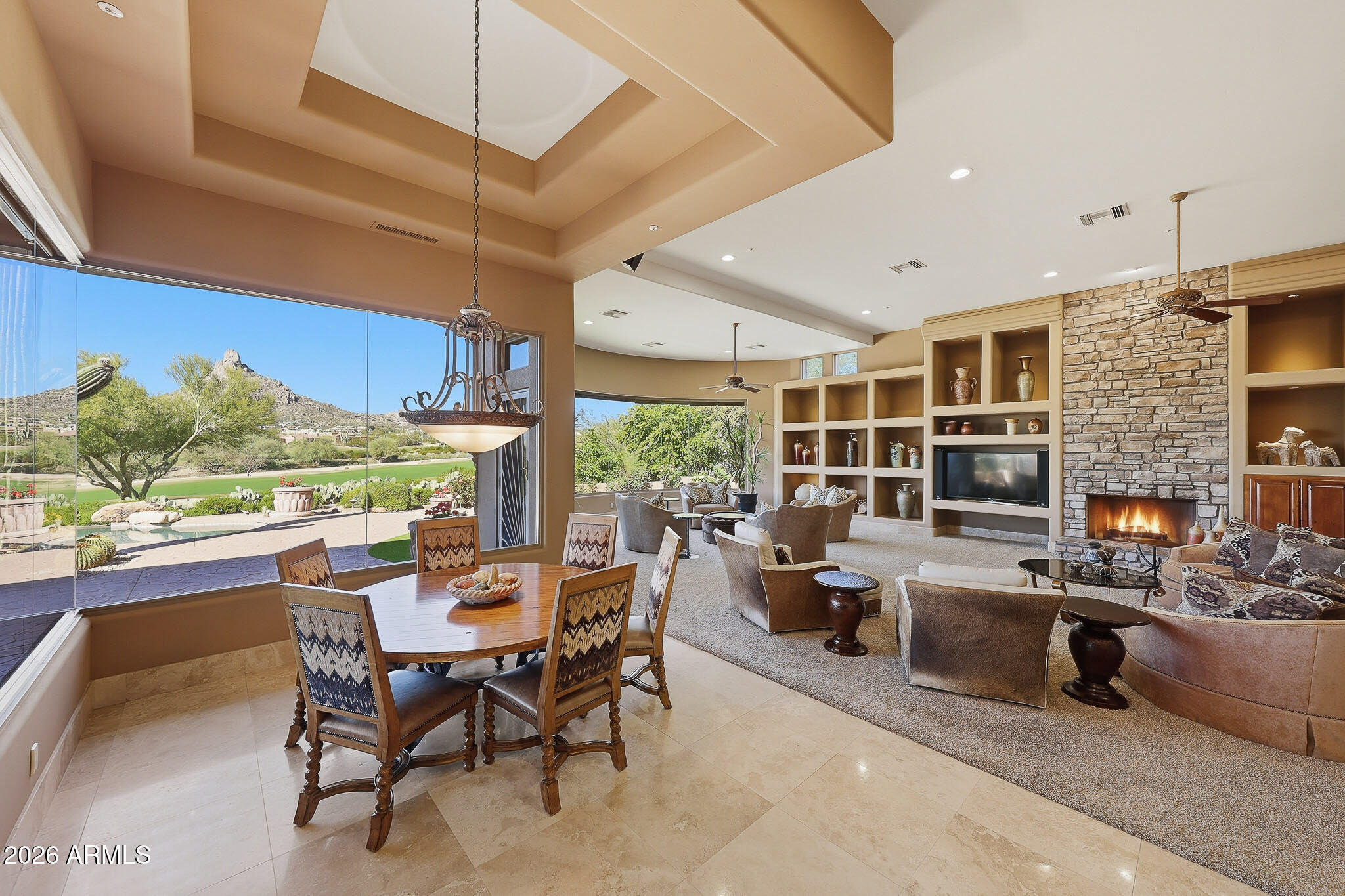 Perfectly positioned along the 8th and 2nd fairways of Troon Country Club, this exceptional residence enjoys a rare and highly coveted double-fairway setting within guard-gated Windy Walk Estates in Troon Village - just a short walk to the clubhouse. Showcasing Pinnacle Peak views, single-level living, and a four-car garage, this home presents a truly rare opportunity in one of North Scottsdale's most prestigious golf communities.
Offering 6,691 square feet, 5 bedrooms, 5.5 baths, and a true 4-car garage, this no-step residence delivers effortless luxury living with dramatic golf course, mountain, city-light, and sunset views. The open, thoughtfully designed floor plan features soaring ceilings and a grand great room anchored by a gourmet kitchen with large U-shaped island, stainless appliances, custom wood cabinetry, and stone countertopsseamlessly flowing into the family room for easy entertaining.
Formal living and dining spaces connect to a wet bar with wine refrigerator and ice maker, creating an ideal layout for hosting. All guest bedrooms are generously sized en suite, each featuring walk-in showers and walk-in closets.
The primary retreat is privately situated and offers a sitting area with fireplace, spa-inspired bath with soaking tub, dual vanities, separate water closets, and a custom walk-in closet.
Outdoor living is equally impressive, featuring a heated pool and spa, expansive covered patio, built-in BBQ, outdoor fireplace, and multiple seating areaseach perfectly positioned to take in breathtaking fairway and Pinnacle Peak vistas.
Additional highlights include a large laundry room, abundant storage, and recent improvements: flat patio roof recoated in 2026, main sandcast tile roof underlayment replaced approximately five years or newer, and three HVAC systems (2014, 2015, and 2015).