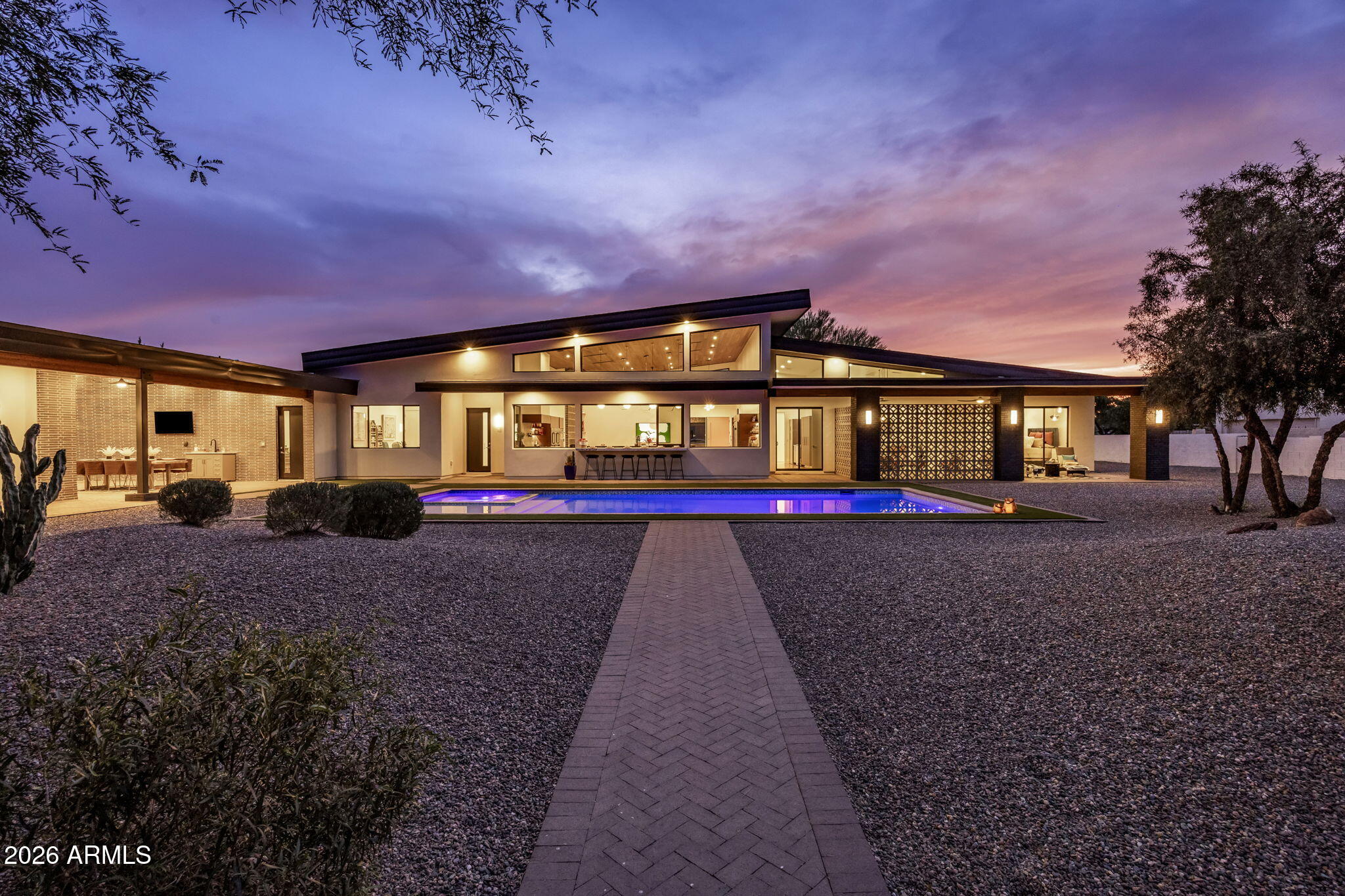 In one of Scottsdale's most sought-after pockets, the Cactus Corridor, this custom single-level estate offers a lifestyle defined by space, privacy, and effortless luxury, just minutes from the very best of either North Scottsdale or Old Town Scottsdale.

Set on over an acre with no HOA and a rare sewer connection (not septic), this fully rebuilt 2022 mid-century-inspired residence pairs architectural character with modern finishes. Stepping inside, the 17-foot vaulted wood-clad ceilings, designer lighting, and a dramatic skylight over the geometric breeze-block fireplace create an elevated yet inviting atmosphere in the 1,400 square foot great room.

The thoughtfully designed main residence includes 4 bedrooms, 4 bathrooms, and a versatile bonus room ideal for an office, playroom, or gym. Two junior suites feature spa-like ensuite baths, custom built-in desks, beverage fridges, and designer walk-in closets. At the center of the home, the chef's kitchen impresses with a 14-foot waterfall-edge quartz island with reclaimed-wood bar seating, double Café French-door ovens, an 8-burner gas range, convection microwave, and telescoping windows that open to an outdoor bar for seamless entertaining.

Entertain with ease thanks to a fully equipped wet bar featuring a commercial-grade beverage refrigerator, wine storage, a gourmet coffee station, and a signature "sonic" ice machine.

Step outdoors to enjoy a true resort-style setting with a large, heated pool and spa, a 6-hole putting green, and an expansive covered patio with fireplace and mounted TVs. Multiple seating areas, a built-in natural-gas grill, and outdoor dining space are framed by mountain views and peaceful surroundings--yet you're just minutes to Scottsdale Airpark, Kierland Commons, Scottsdale Quarter, Scottsdale Fashion Square, premier dining and golf, and the Loop 101.

With over an acre of usable land, the property offers outstanding flexibility for future additions within the building envelope. Whether envisioning a secondary guest casita, RV garage, pickleball court, or even equestrian use, the space allows for a wide range of possibilities tailored to your lifestyle.

A standout feature is the 1,450 sq ft luxury guest house--fully self-contained with its own kitchen, living area, office, private laundry, spacious bedroom, oversized walk-in closet, and designer bath. Ideal for guests, multigenerational living, extended stays, or a private retreat.

Additional highlights include a dedicated home gym, hidden electronic roller shades on all windows, built-in indoor/outdoor sound system, water filtration, an indoor pet spa/dog wash, and abundant storage throughout.

Located between two Mayo Clinic campuses and surrounded by expansive custom estates, this is one of the few opportunities in Scottsdale where you can truly have it all: land, privacy, flexibility, and proximity. A rare offering that delivers both lifestyle and long-term value in one of North Scottsdale's most desirable corridors.