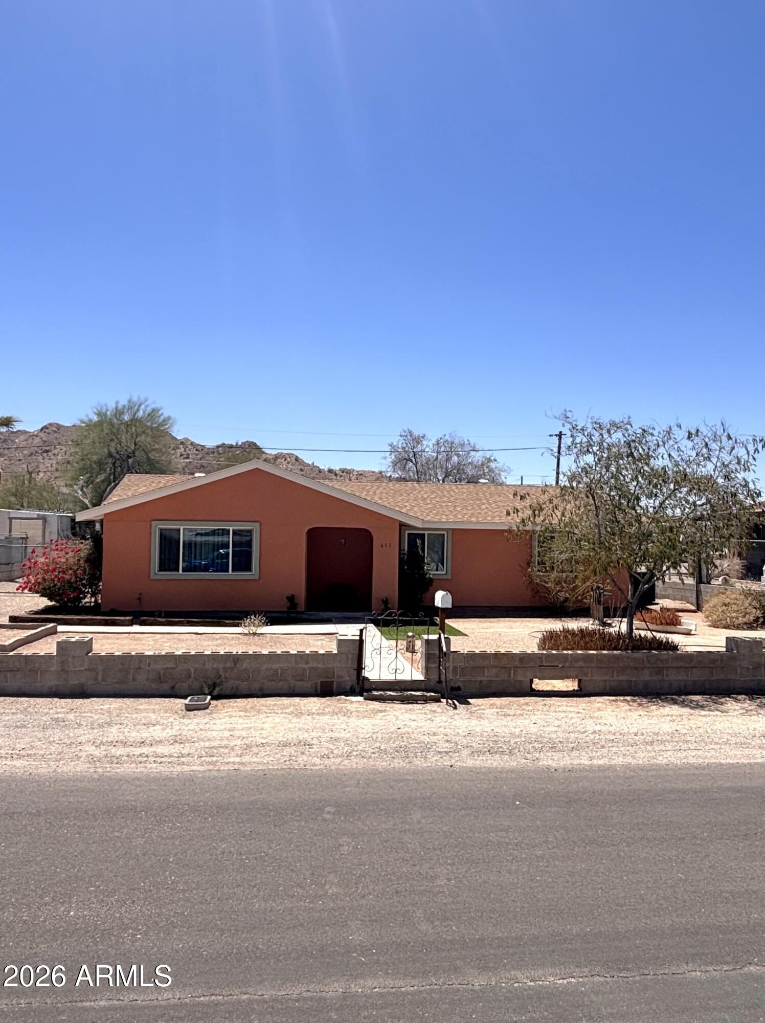 Professionally remodeled and ready for occupancy,  This 3-bedroom, 2-bath home offers 1,328 sq. ft. of comfortable living space with a stucco exterior, new roof, laminate flooring, updated bathrooms, and vinyl windows throughout. The spacious living area flows into an open kitchen featuring a gas range, built-in microwave, and refrigerator. The primary suite boasts a custom tiled walk-in shower with designer accents. Washer and dryer convey. Outside, enjoy RV gate access, additional parking, a large backyard with mountain views, and a quiet street location. Situated in historic Ajo, known for its charming town plaza, desert beauty, and easy access to the beaches and fishing destinations of Puerto Peñasco, Mexico.