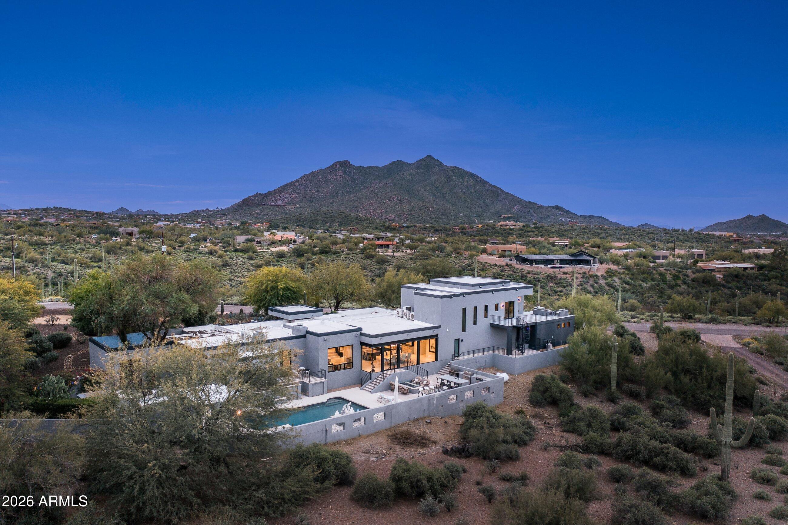 A striking contemporary desert estate set on 2.1 acres with panoramic mountain views, in a quiet & private pocket of Cave Creek on a desirable north south lot. Completely reimagined & expanded in 2020, this residence showcases modern architecture defined by clean lines, expansive glass, & a seamless indoor outdoor connection that makes you feel immersed in the surrounding desert. Thoughtfully curated finishes, emphasizing quality materials & custom detailing. The home has 4 ensuite bedrooms, including 2 primary suites, with the main retreat opening to a private view deck with pool access. Resort style backyard with kitchen & dining, fire pit, a statement pool & lounging gazebo, & existing equestrian amenities complete the property. Minutes from dining, art galleries, shopping, & hiking.